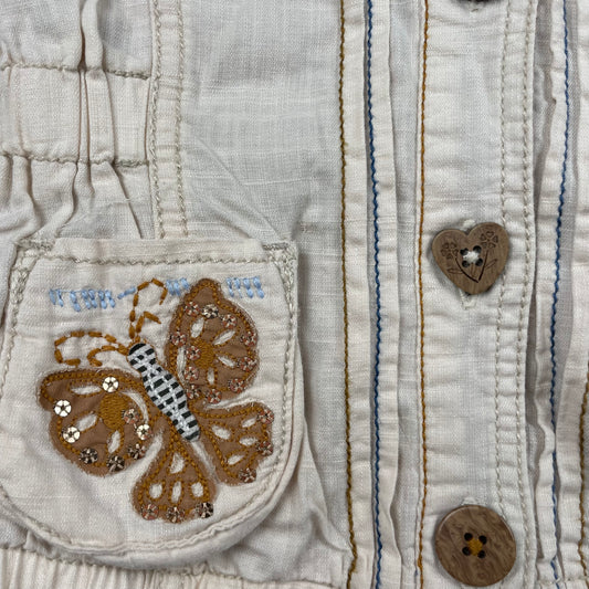 Beige Kapuzenjacke mit Schmetterlingsmotiven auf den Taschen – detail