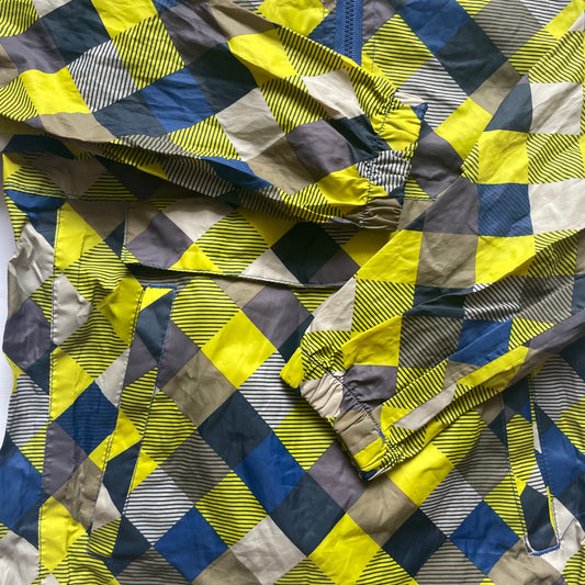 Mehrfarbige Regenjacke mit Kapuze und quadratischem Muster – detail