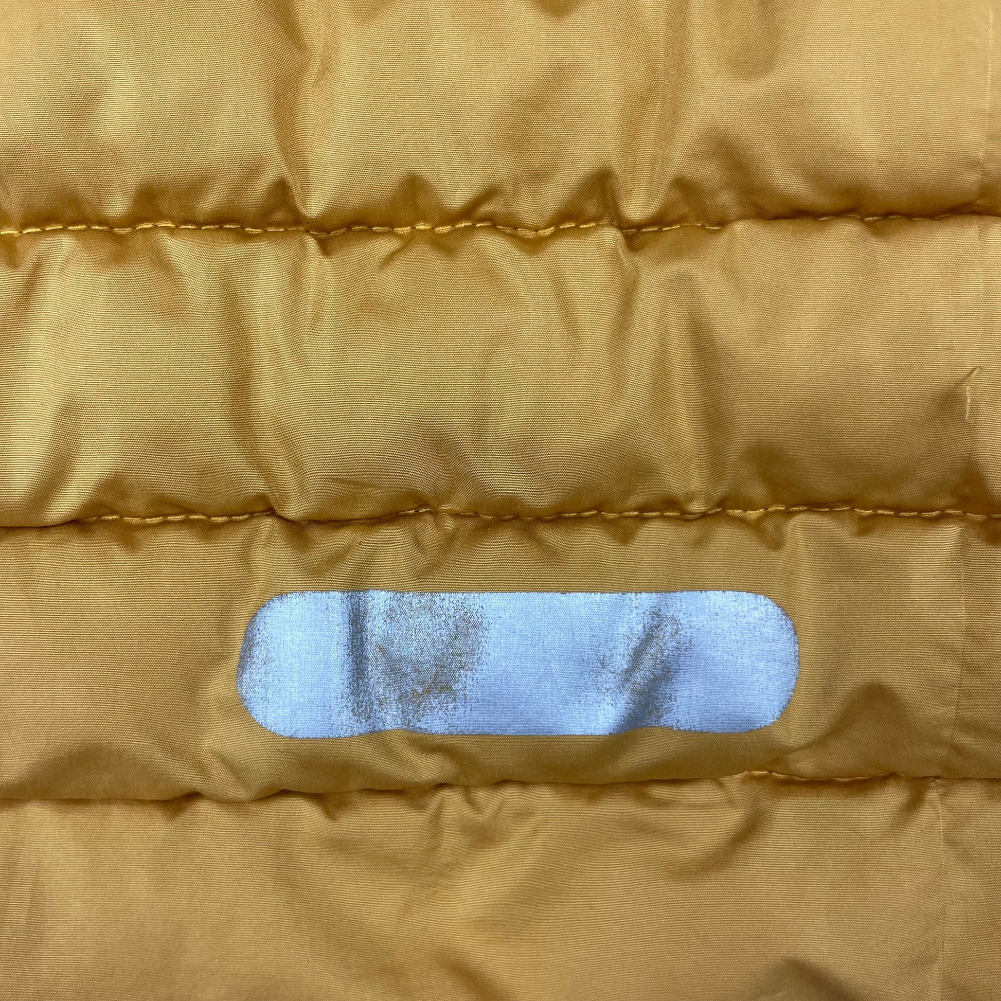 Senfgelbe Kinder-Steppjacke von Nordbjørn mit Kapuze, Reißverschluss und reflektierenden Details. – button