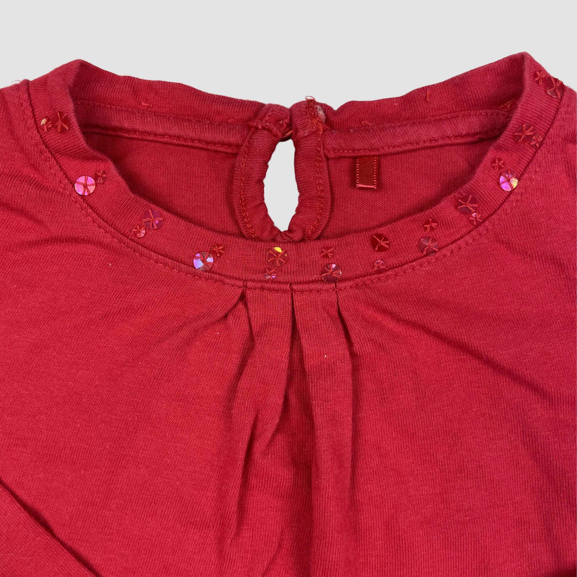 Rotes Langarmshirt von George aus Baumwolle mit Pailletten am Ausschnitt und kleiner Tasche mit Schleife, Größe 3–4 Jahre (98–104 cm) – detail