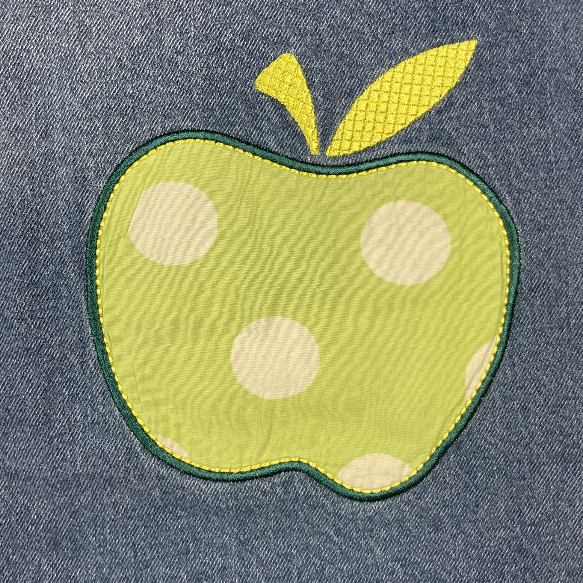 Ärmelloses Jeanskleid mit grüner Apfel-Applikation und Rüschenknopfleiste – detail