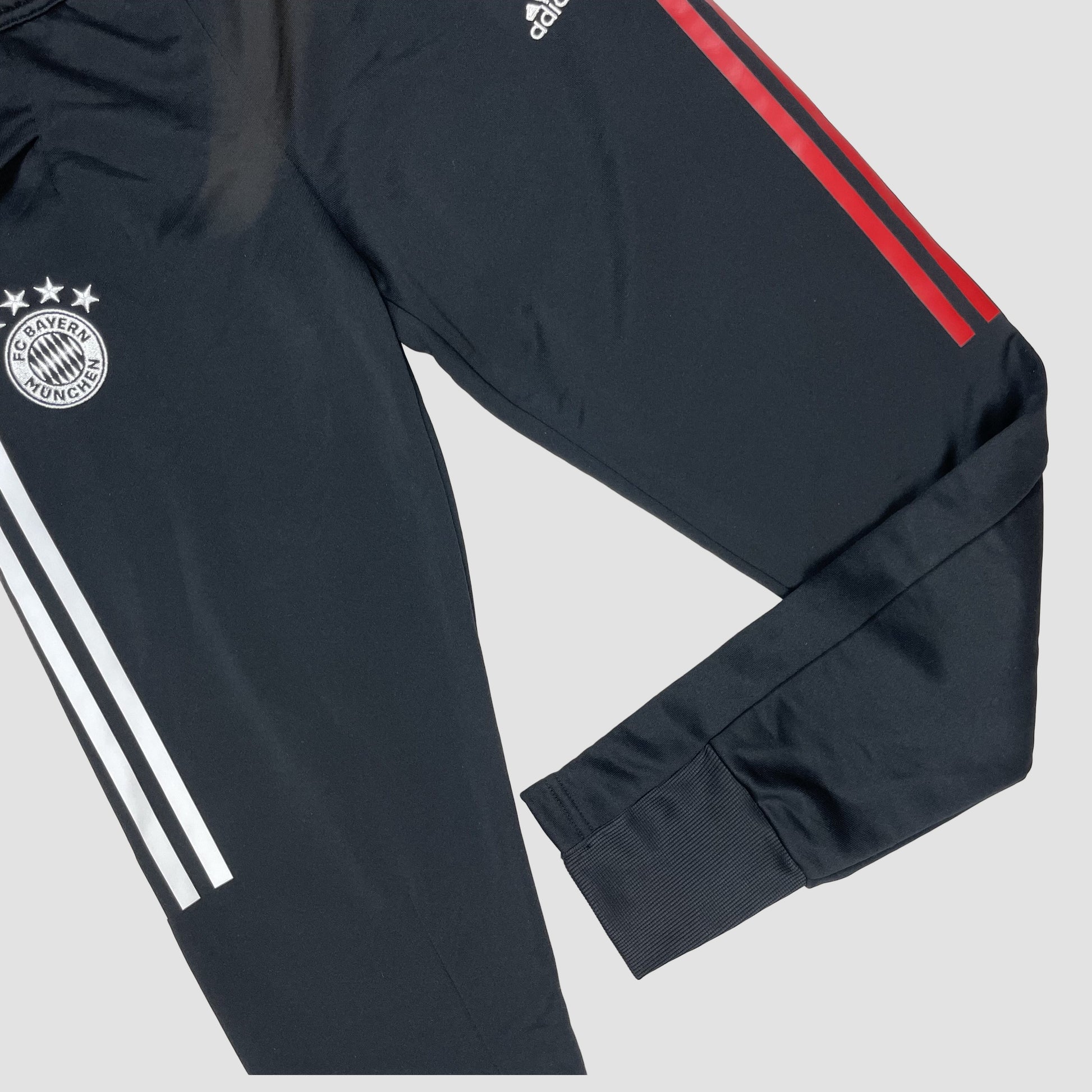 Schwarze Kinder-Trainingshose mit weißen und roten Seitenstreifen und Vereinslogo, Größe 152 – detail