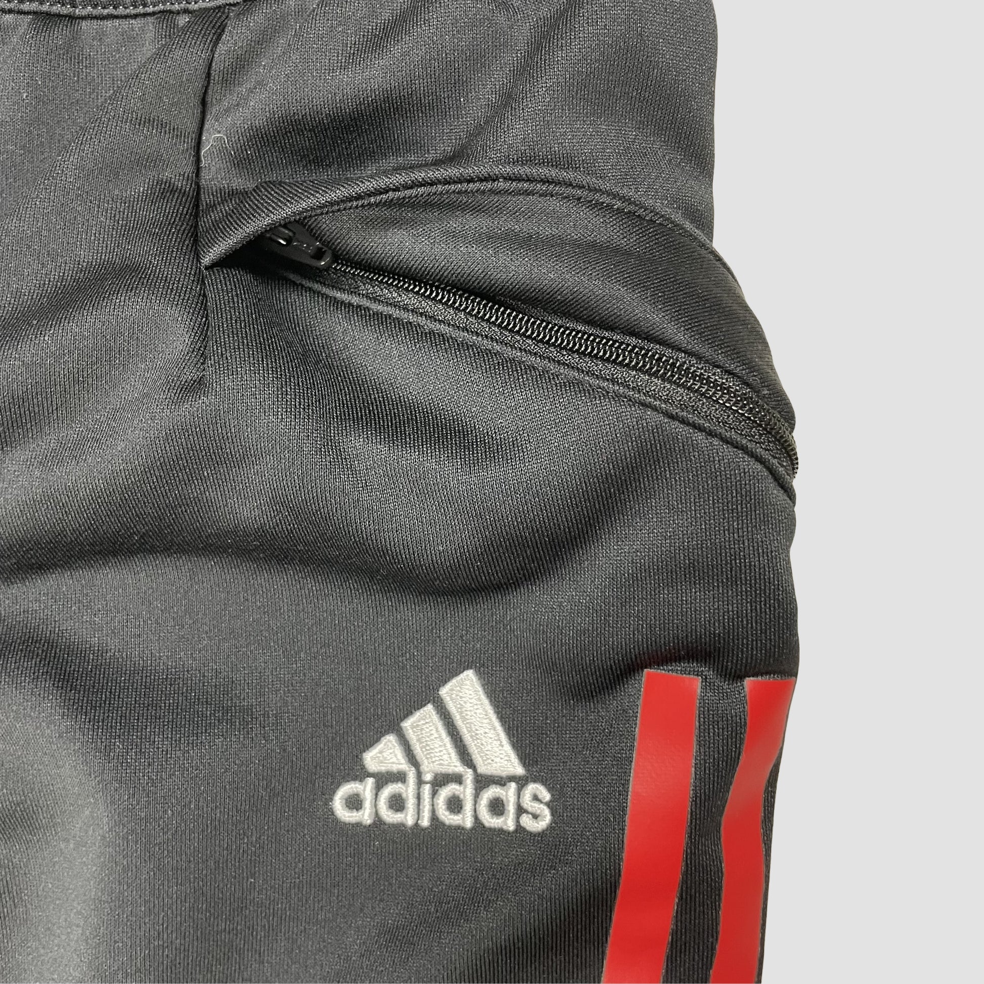 Schwarze Kinder-Trainingshose mit weißen und roten Seitenstreifen und Vereinslogo, Größe 152 – pocket