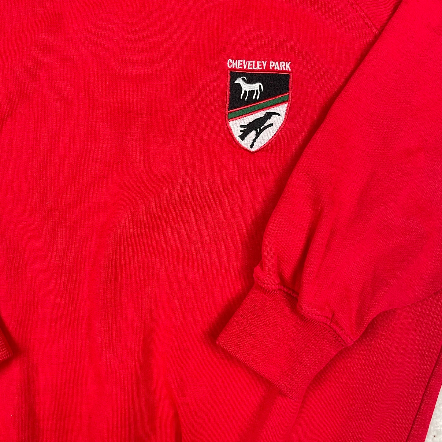 Rotes Kinder-Sweatshirt mit Wappenaufnäher, Rundhalsausschnitt und Bündchen – detail
