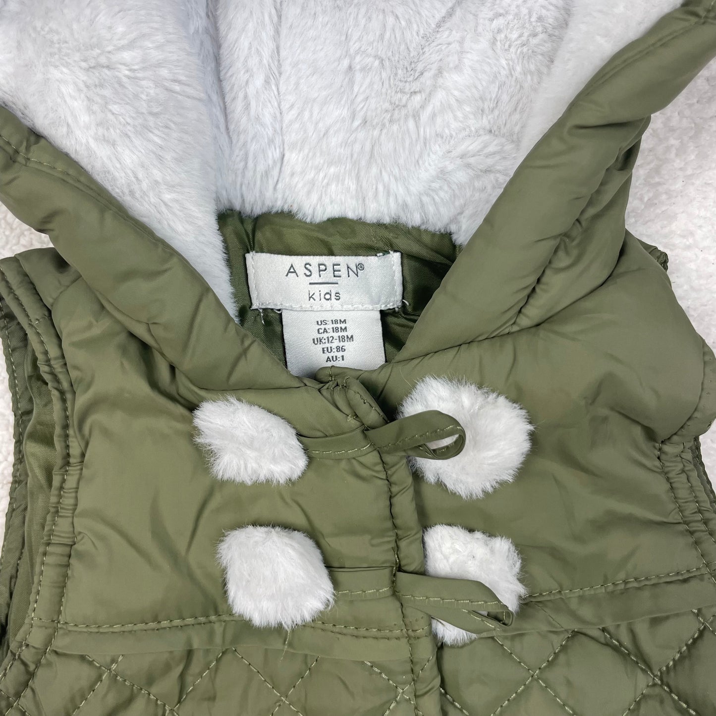 Olivgrüne gesteppte Kinderweste mit Kapuze und Kunstfellfutter, Größe 86 – detail
