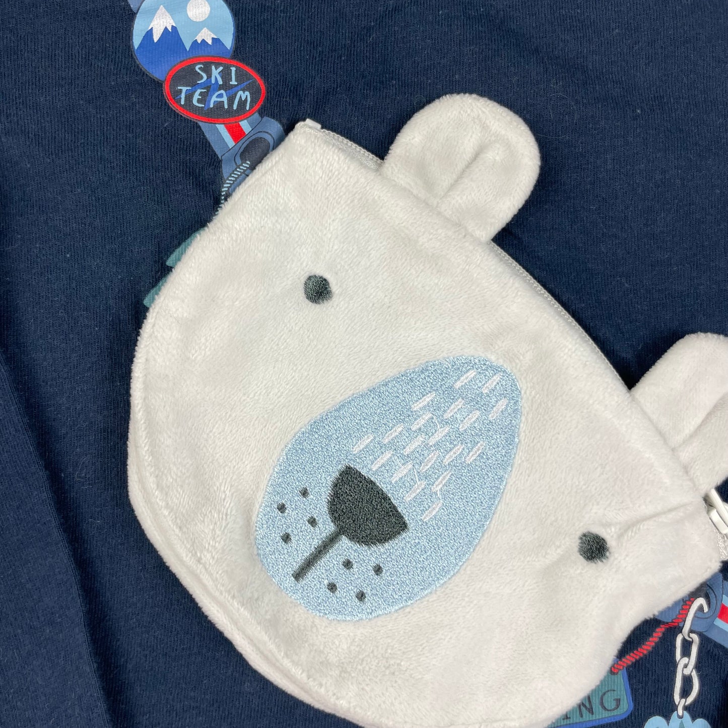 Dunkelblaues Langarmshirt mit applizierter Bären-Tasche und Ski-Details – detail