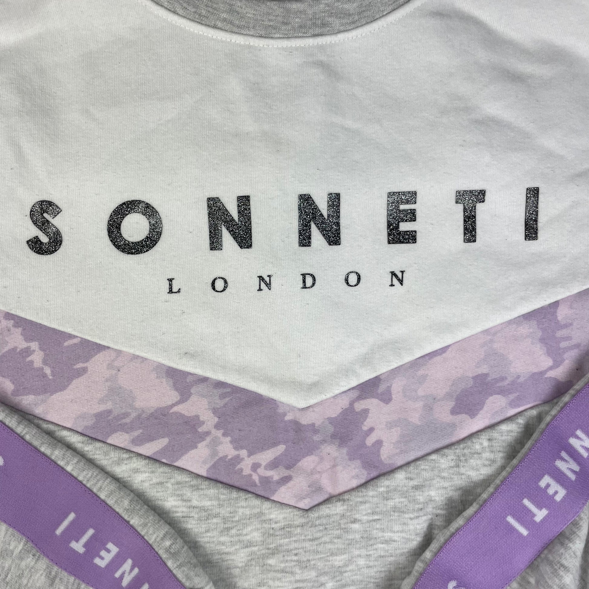 Graues Sweatshirt mit weißer Brustpartie und lilafarbenen Sonneti-Details, Größe 10–12 Jahre – detail