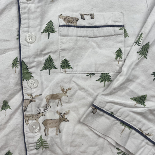 Weißes Schlafanzugoberteil mit Rentier- und Tannenmuster, lange Ärmel und dunkelblaue Paspeln – detail