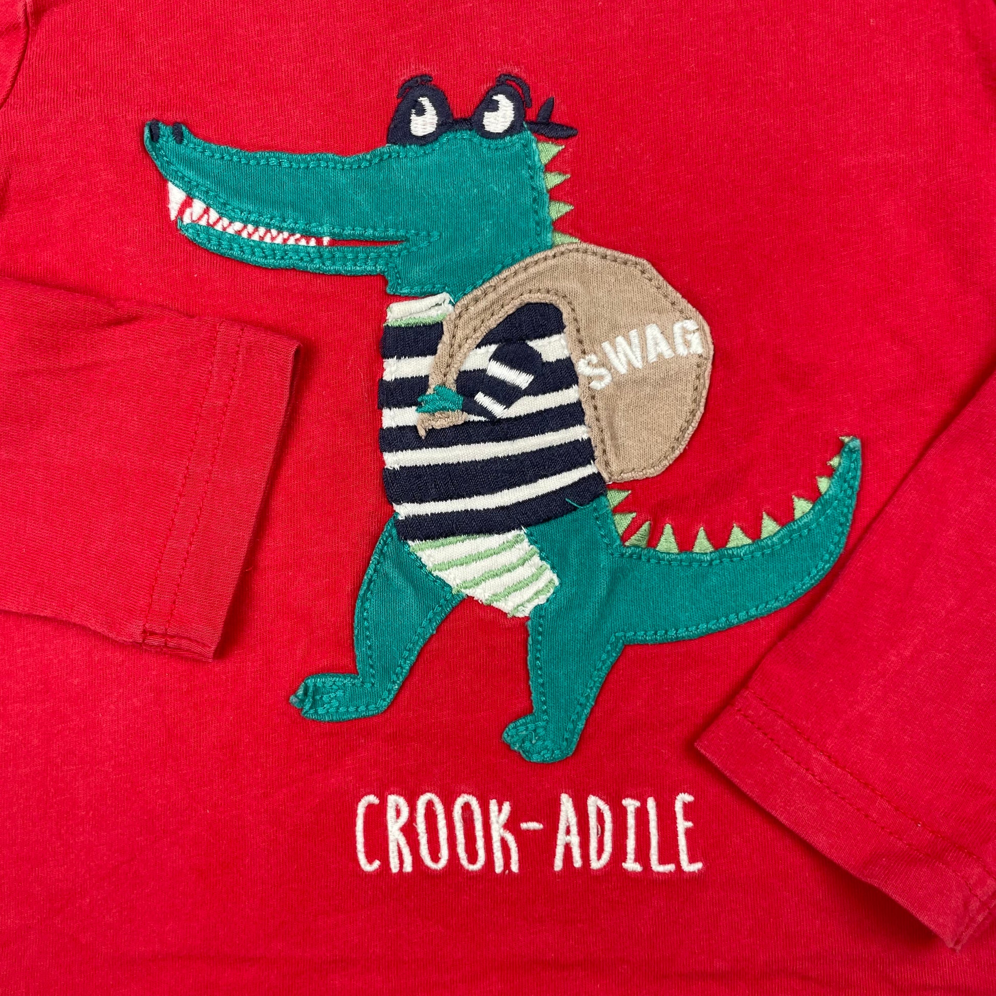 Rotes Langarmshirt mit Krokodil-Applikation vorne – detail