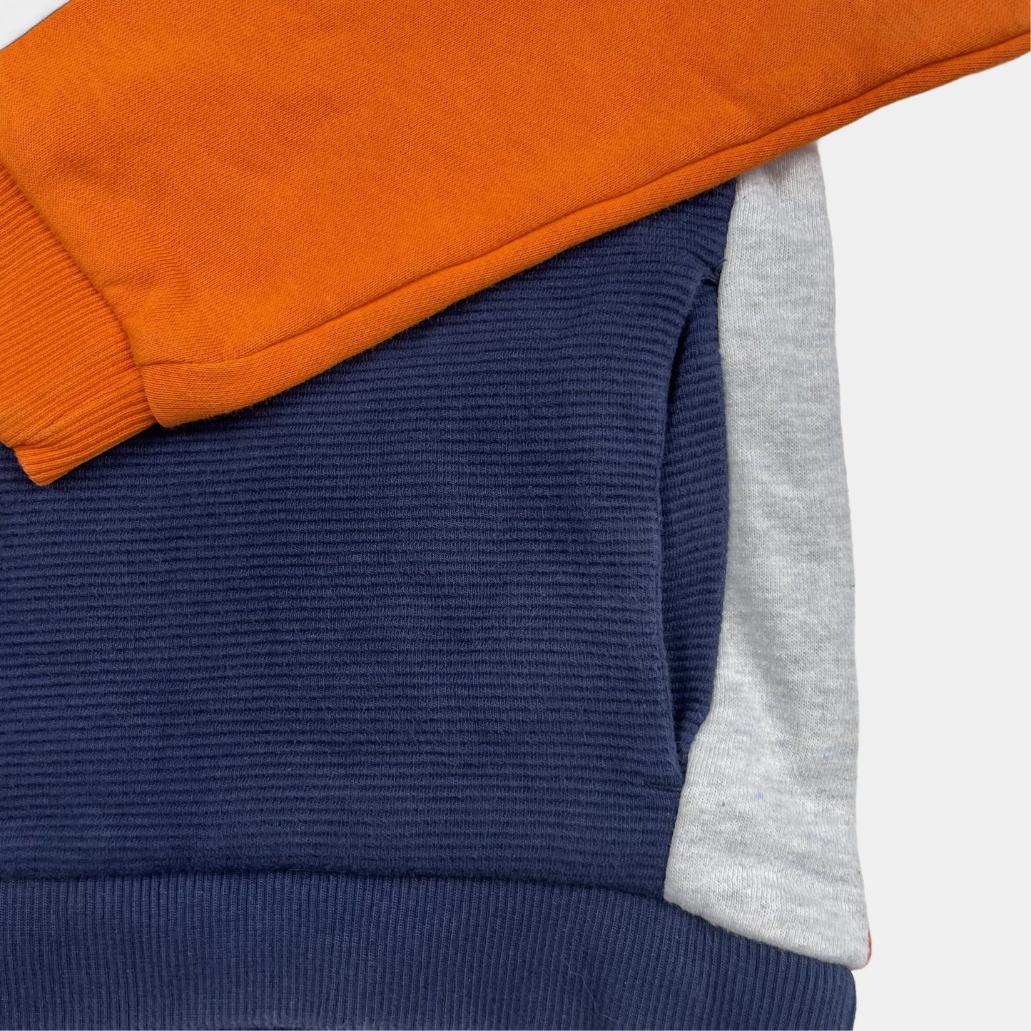 Orange-blauer Kapuzenpullover für Kinder mit gestreiftem Muster und Logo-Detail. – pocket