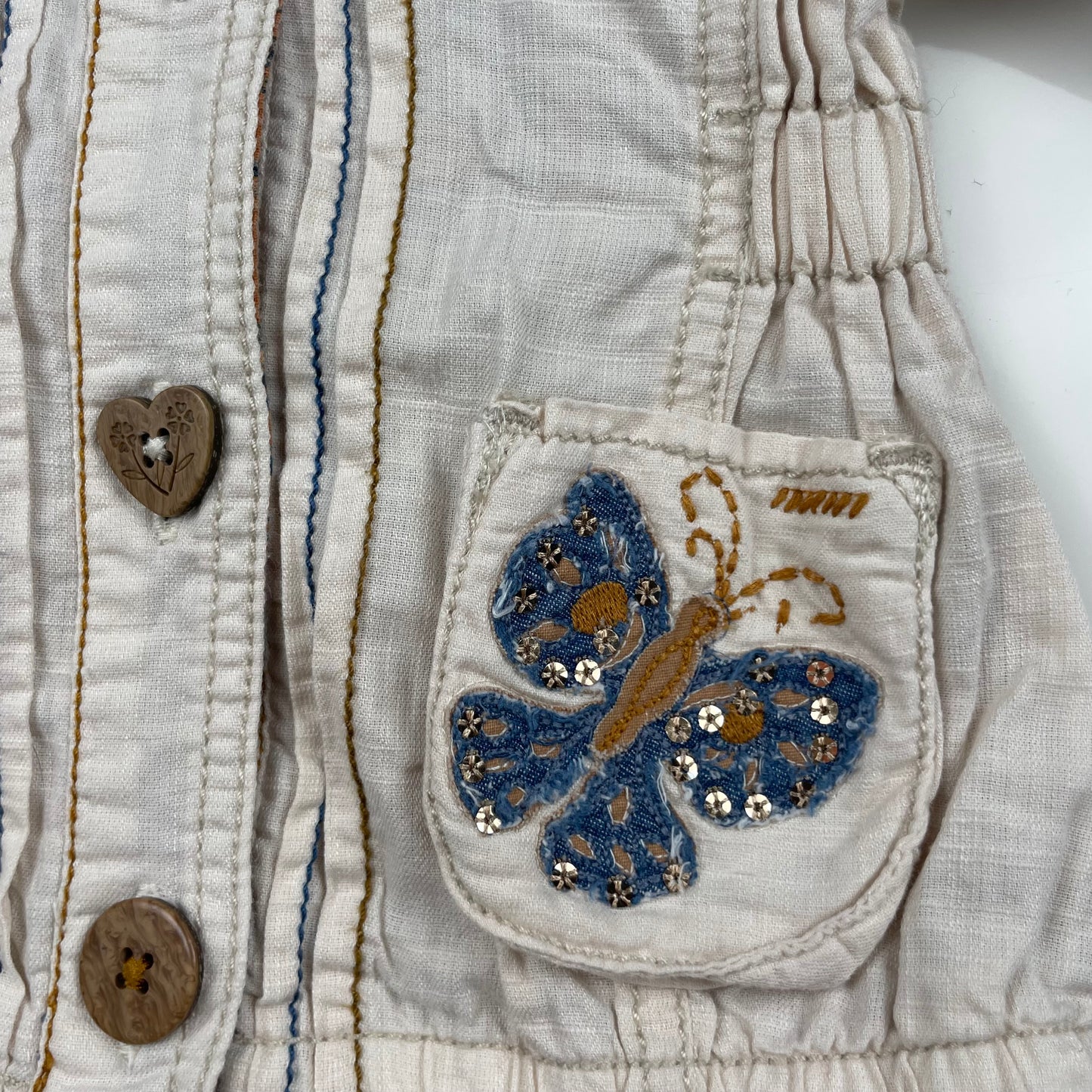 Beige Kapuzenjacke mit Schmetterlingsmotiven auf den Taschen – pocket