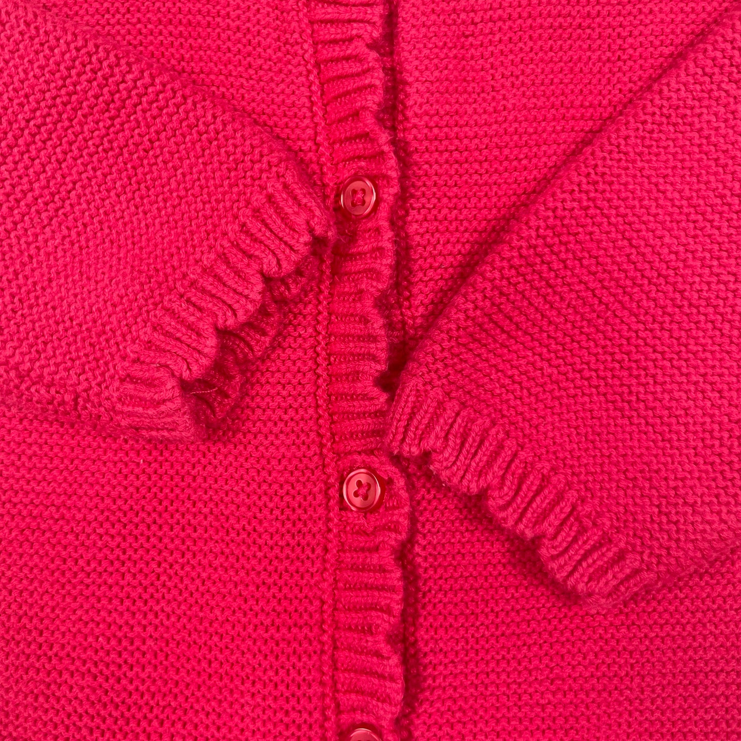 Rote Strickjacke aus Baumwolle mit Rüschenkragen und Knopfleiste. – detail