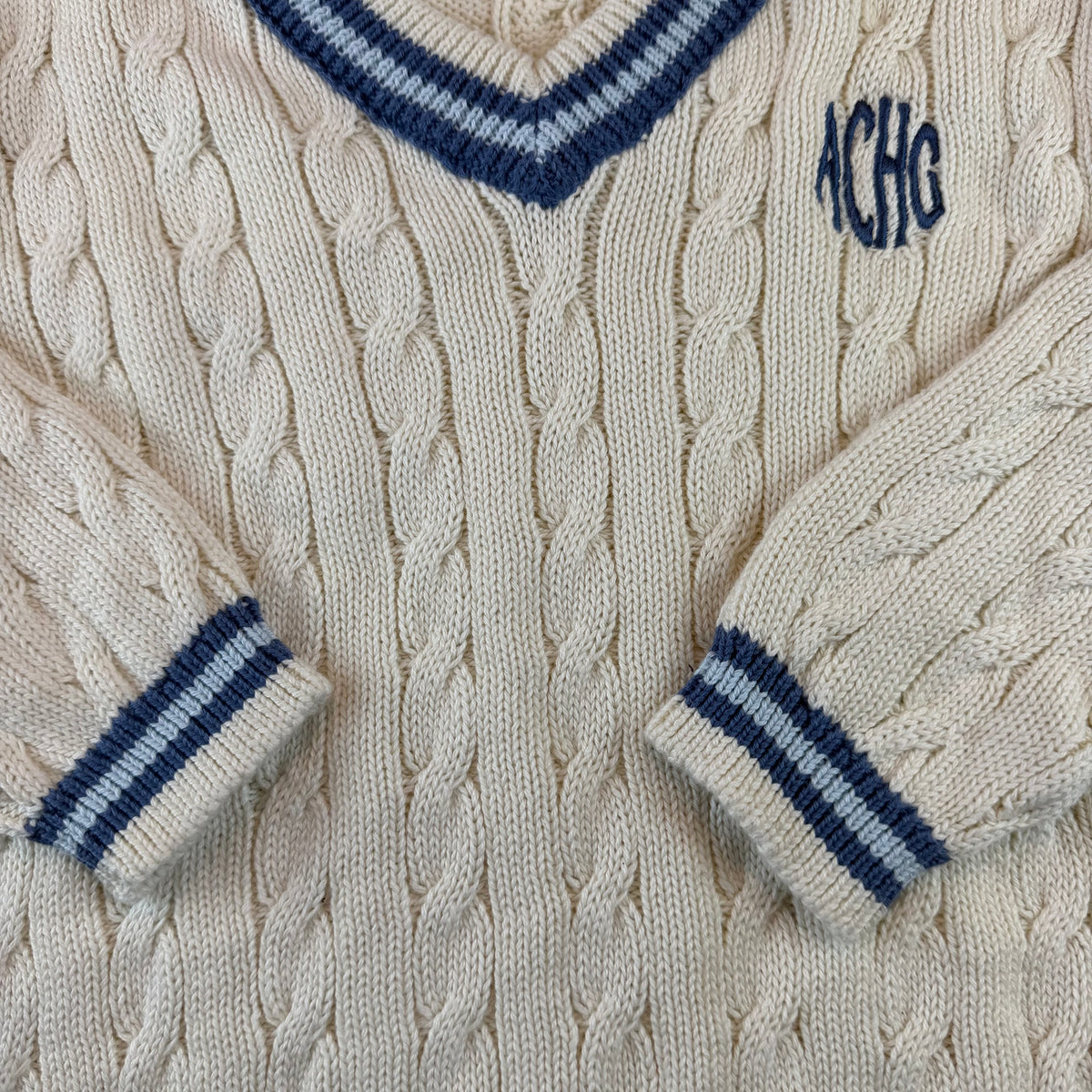 Cremer Kinder-Strickpullover mit Zopfmuster, V-Ausschnitt und blauen Streifenbündchen – sleeve