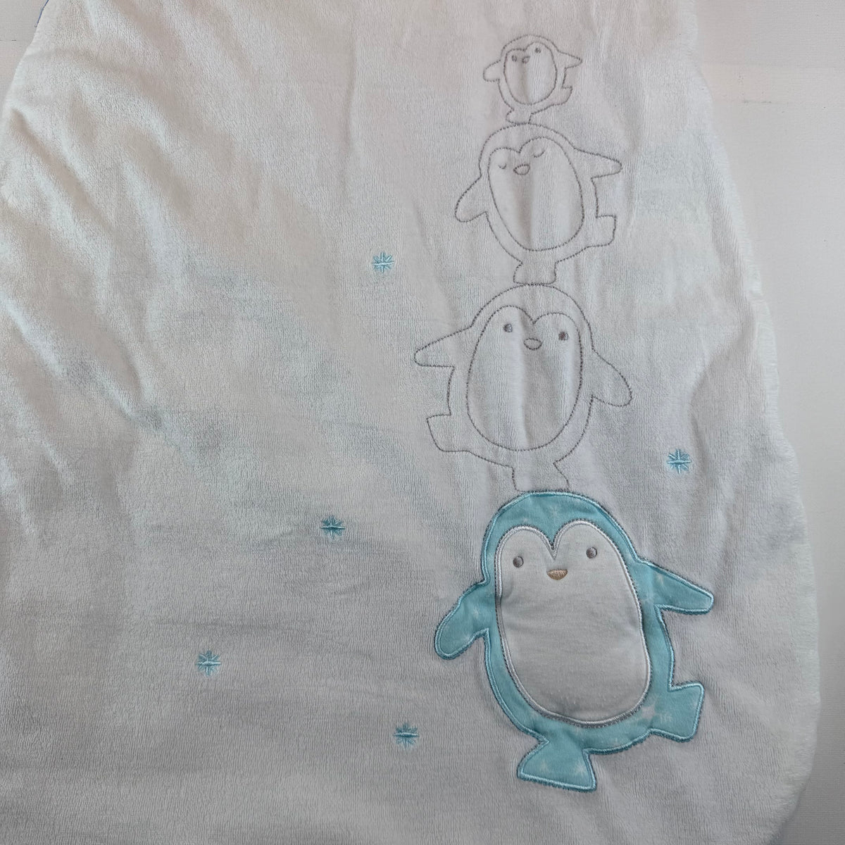 Weißer Baby-Schlafsack mit türkisfarbenem Pinguin-Motiv und Reißverschluss – detail