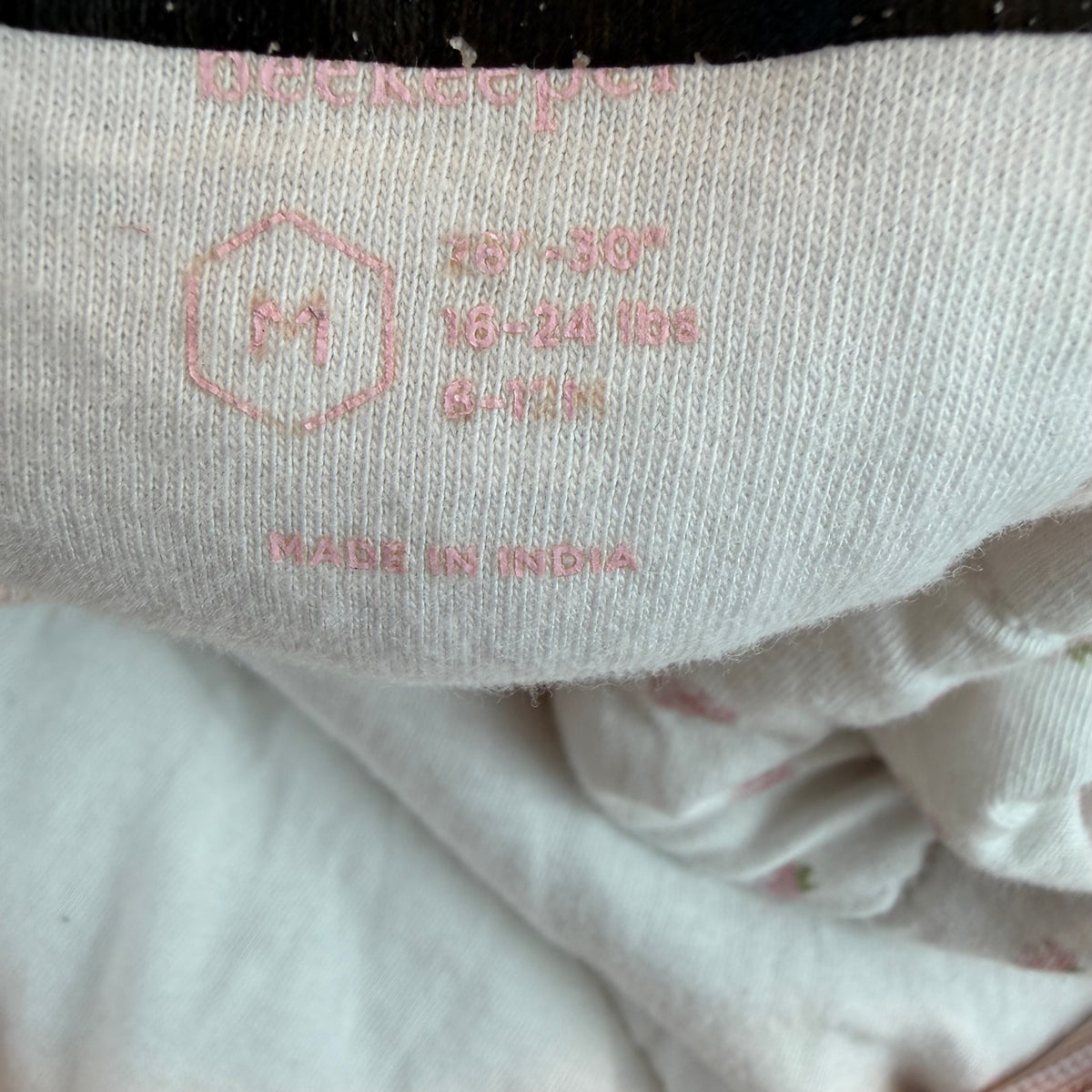 Weißer wattierter Babyschlafsack mit rosa Blümchenmuster und Frontreißverschluss – detail
