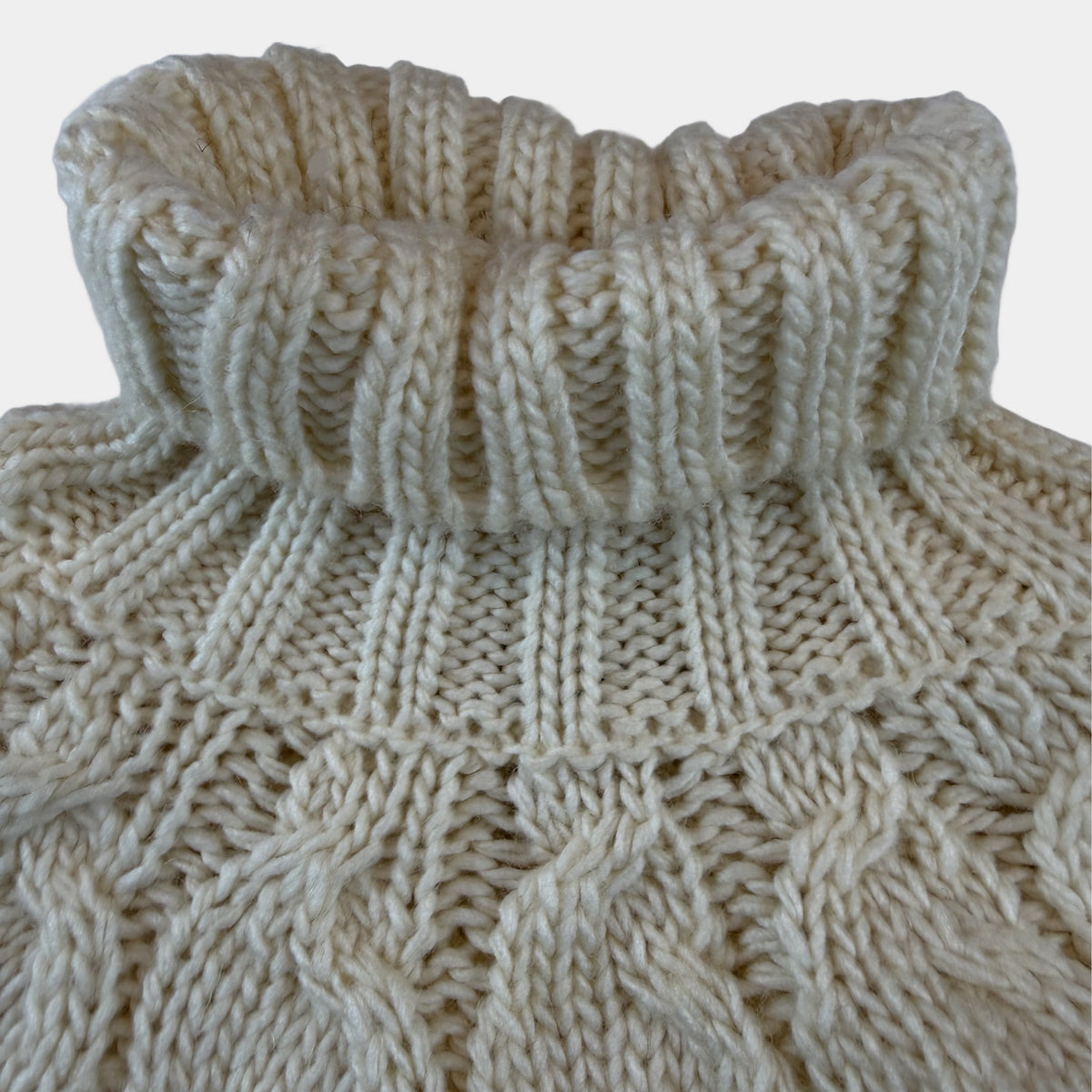 Cremeweißer Strickponcho mit Zopfmuster und Rollkragen für Kinder – detail