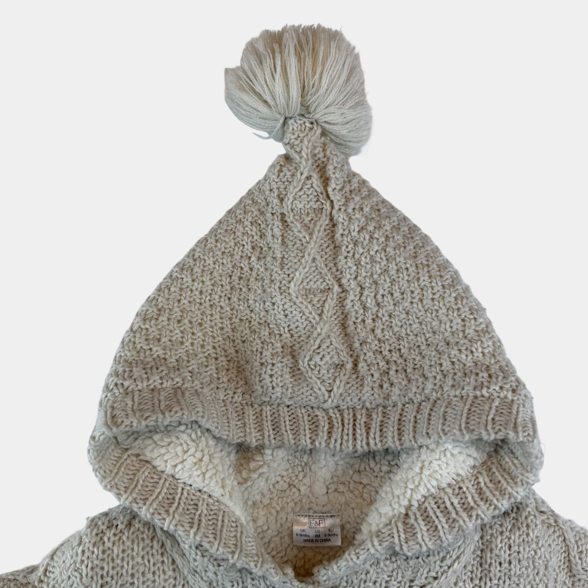 Beige Baby-Strickjacke mit Kapuze, Bommel, Knöpfen und Taschen – detail
