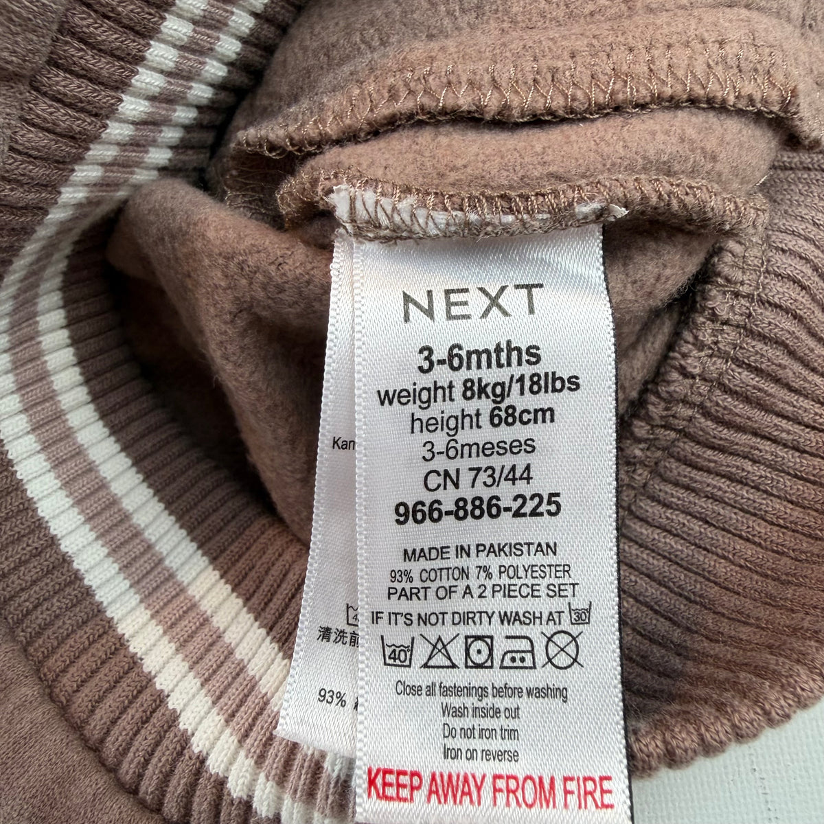 Braune Baby-Collegejacke mit weißen Ärmeln und Druckknöpfen – label