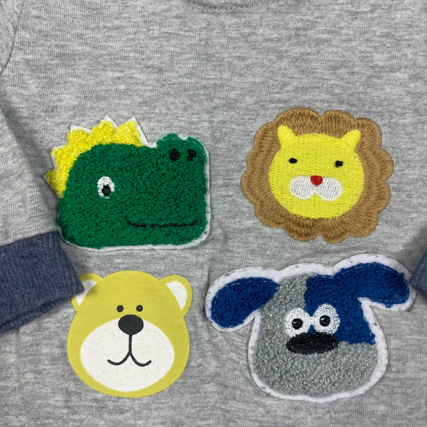 Graues Sweatshirt mit bunten Tiermotiven, lange Ärmel, Knopfleiste an der Schulter – detail