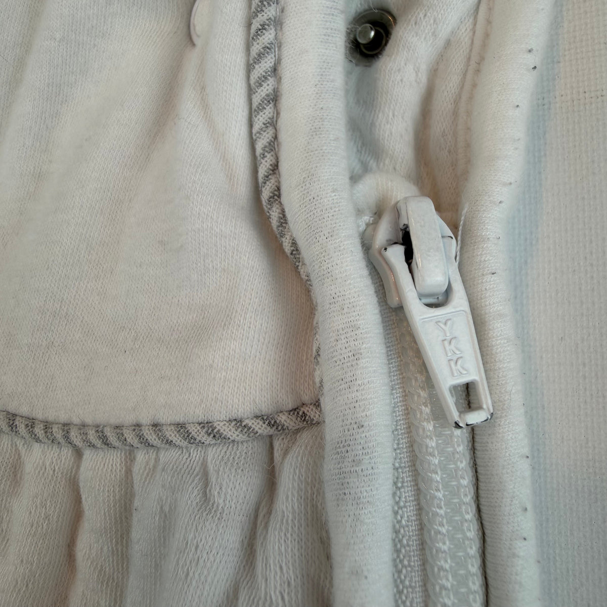 Weißer Babyschlafsack mit seitlichem Reißverschluss und kleinem Stickmotiv – zip