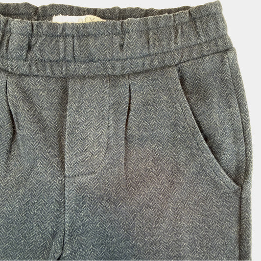 Blaue Kinderhose mit elastischem Bund, Zierknöpfen und seitlichen Taschen – close‑up