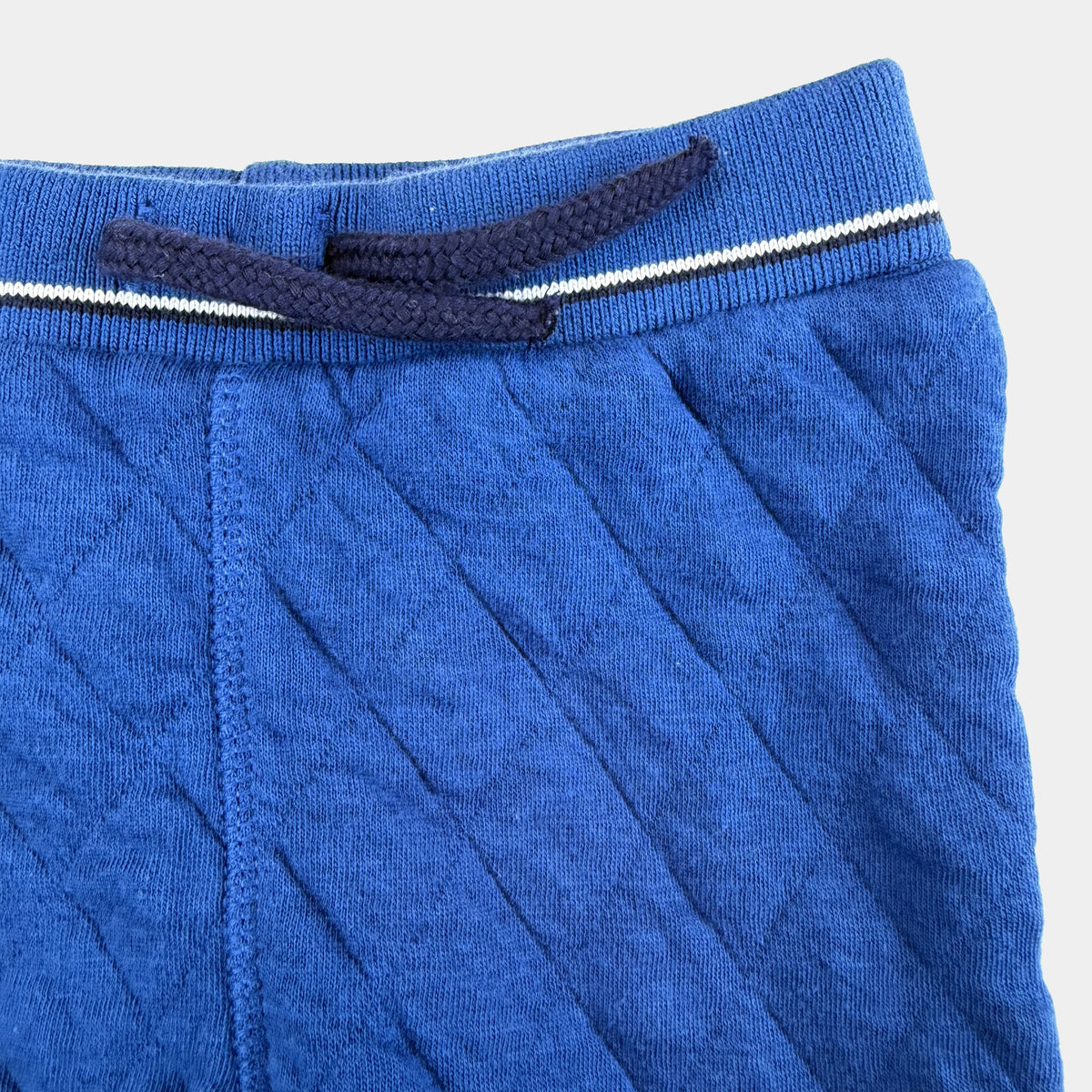 Blaue gesteppte Baby-Jogginghose mit Kordelzug und Rippbündchen – detail