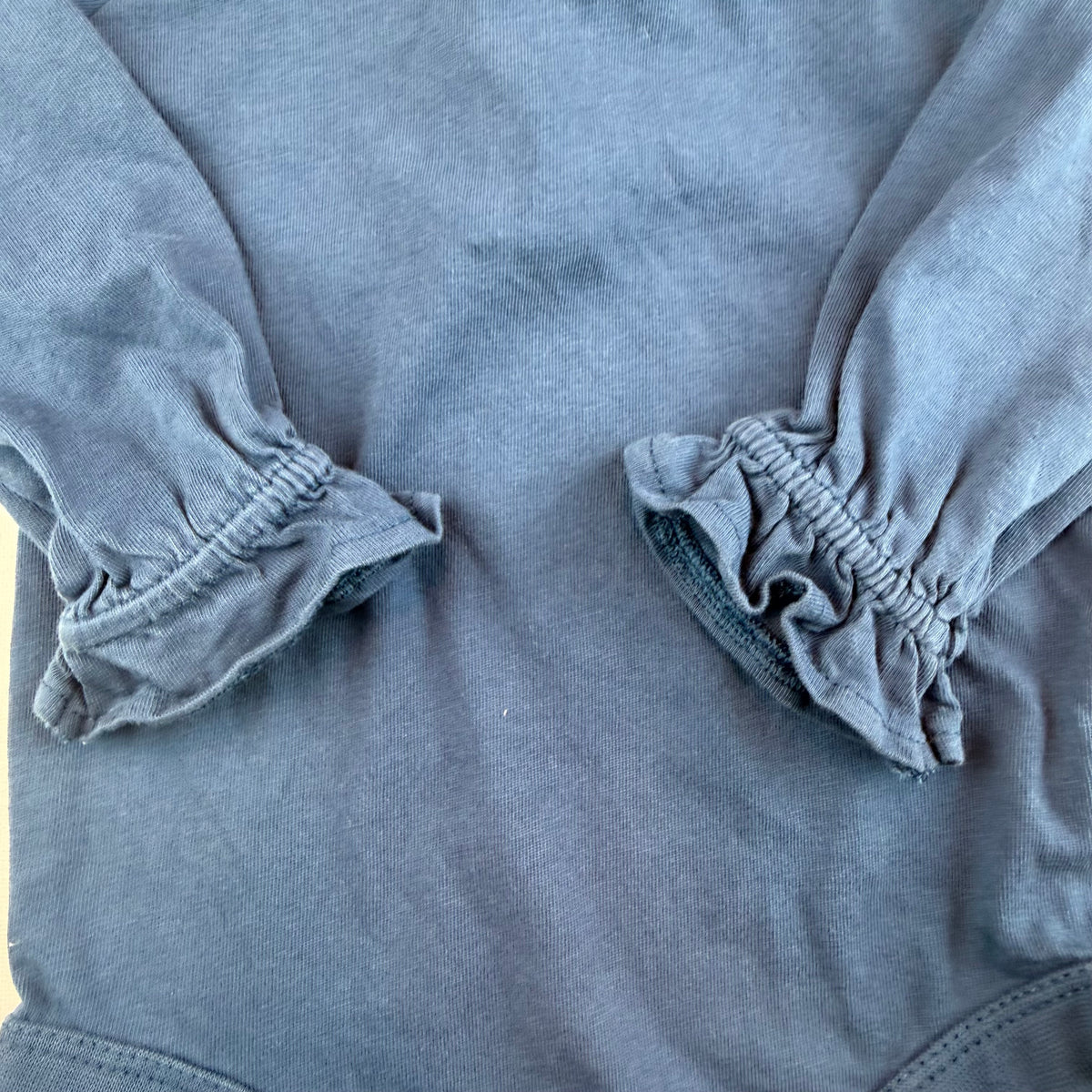 Blauer Langarm-Body mit Rüschenbündchen und Druckknöpfen – detail