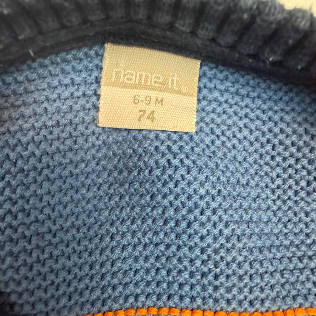 Dunkelblauer Strick-Overall für Babys mit blau-orangen Streifen und Knopfleiste – label