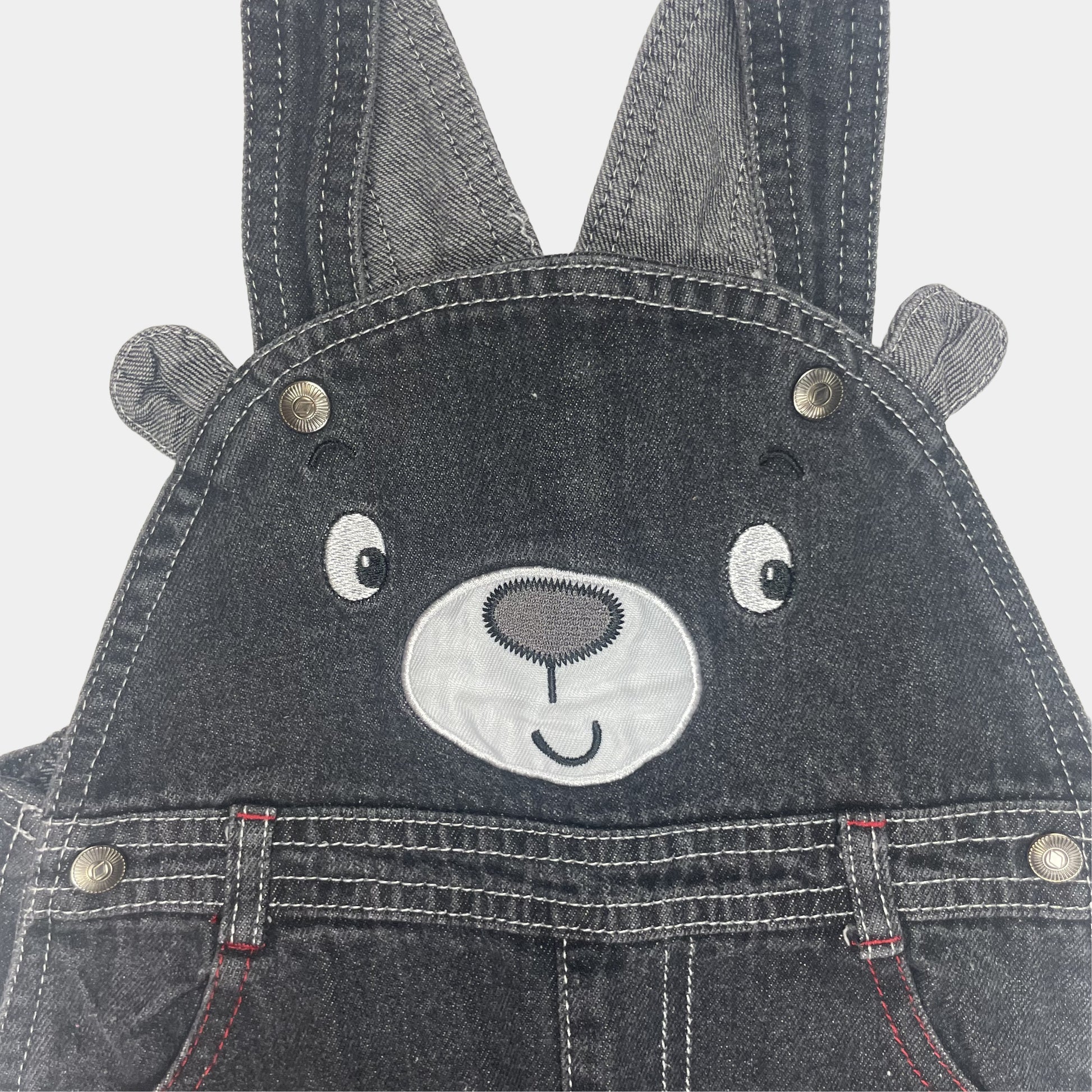 Grauer Denim-Overall mit Bärengesicht und roten Akzenten – detail