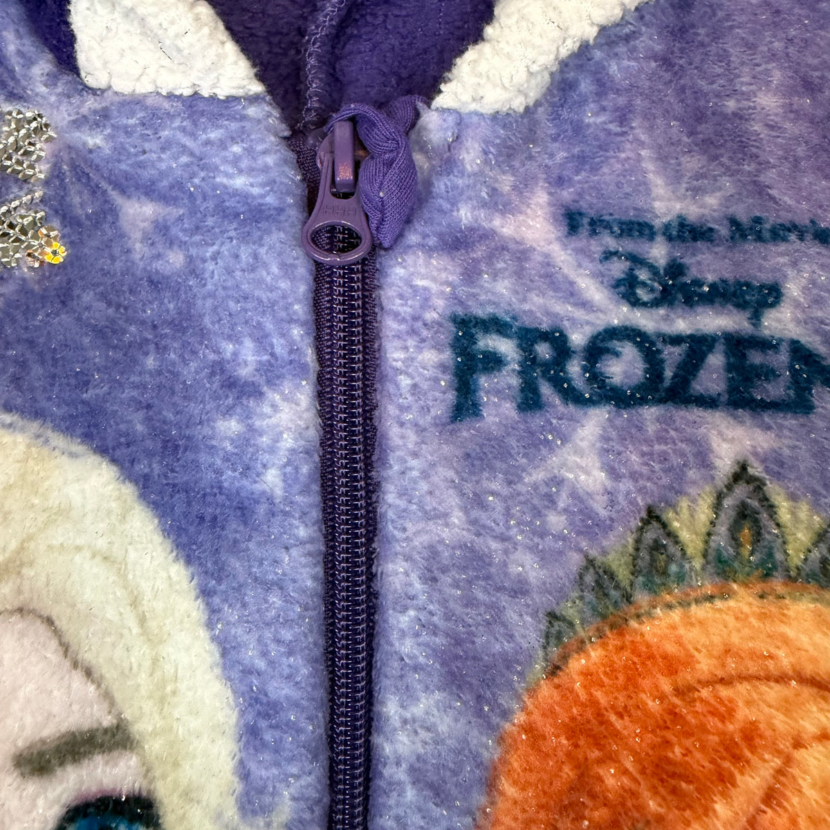 Lila Fleece-Overall für Kinder mit Kapuze, Reißverschluss und Frozen II Motiv – close‑up