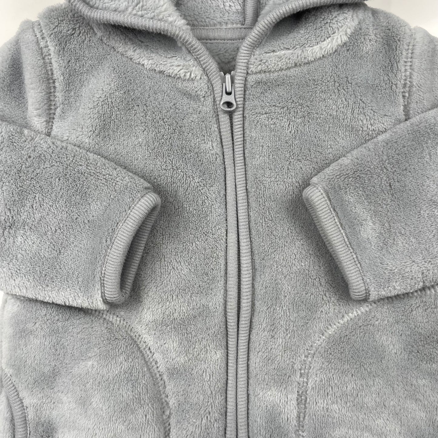 Graue Fleecejacke mit Kapuze und niedlichen Ohren für Babys. – detail