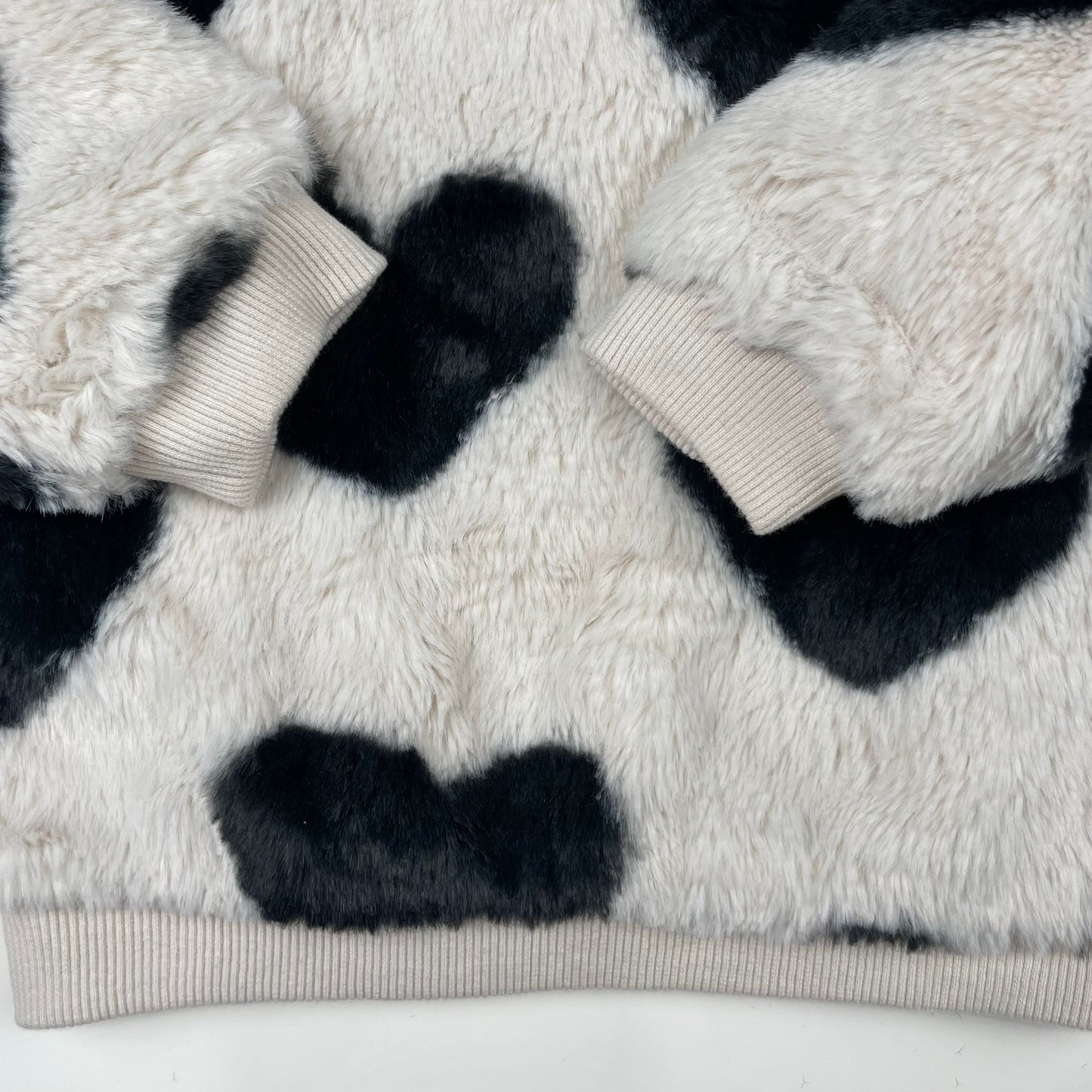 Flauschiger Pullover für Babys mit Herzmuster in Weiß und Schwarz – detail