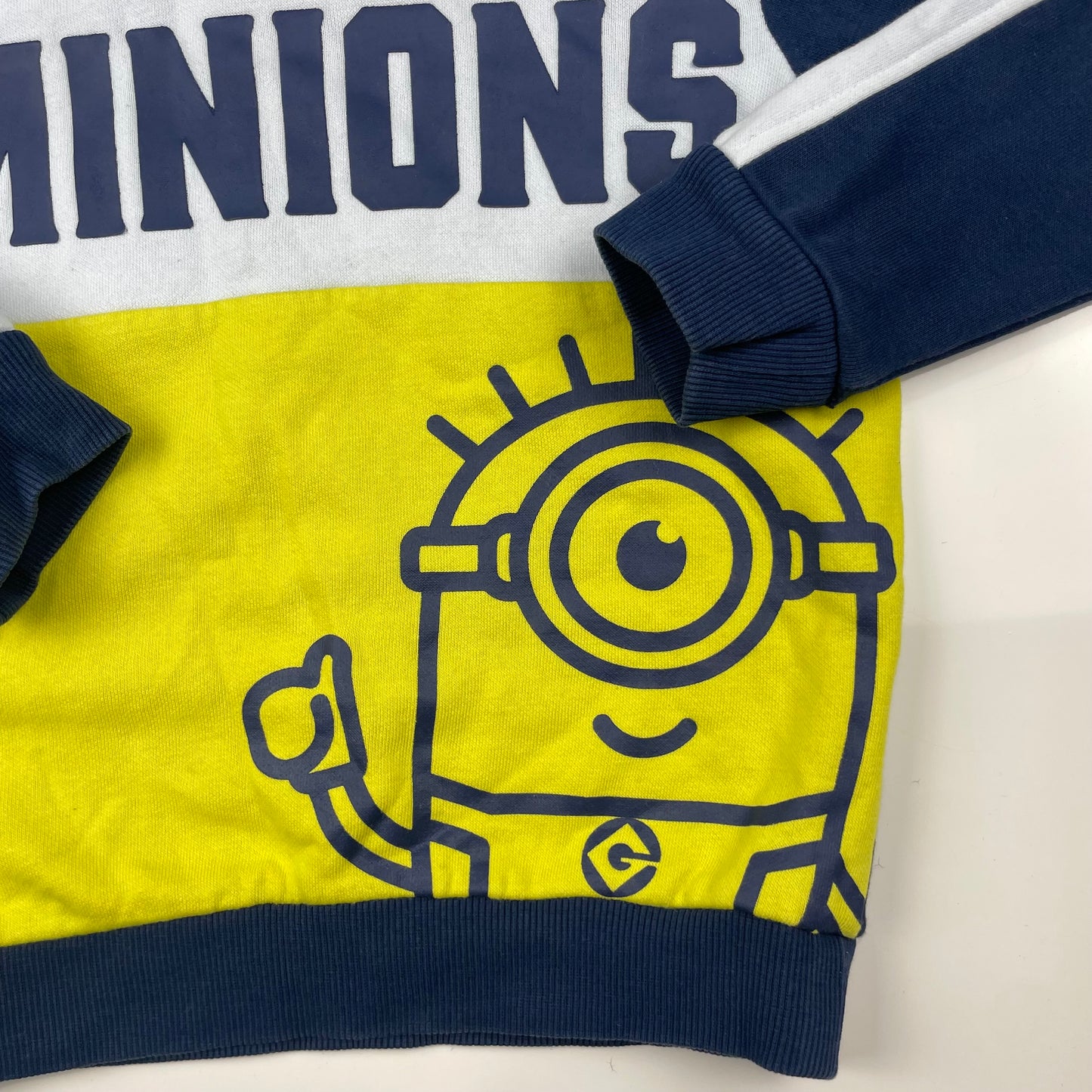 Blauer Kapuzenpullover mit Minions-Motiv und gelben Akzenten – detail