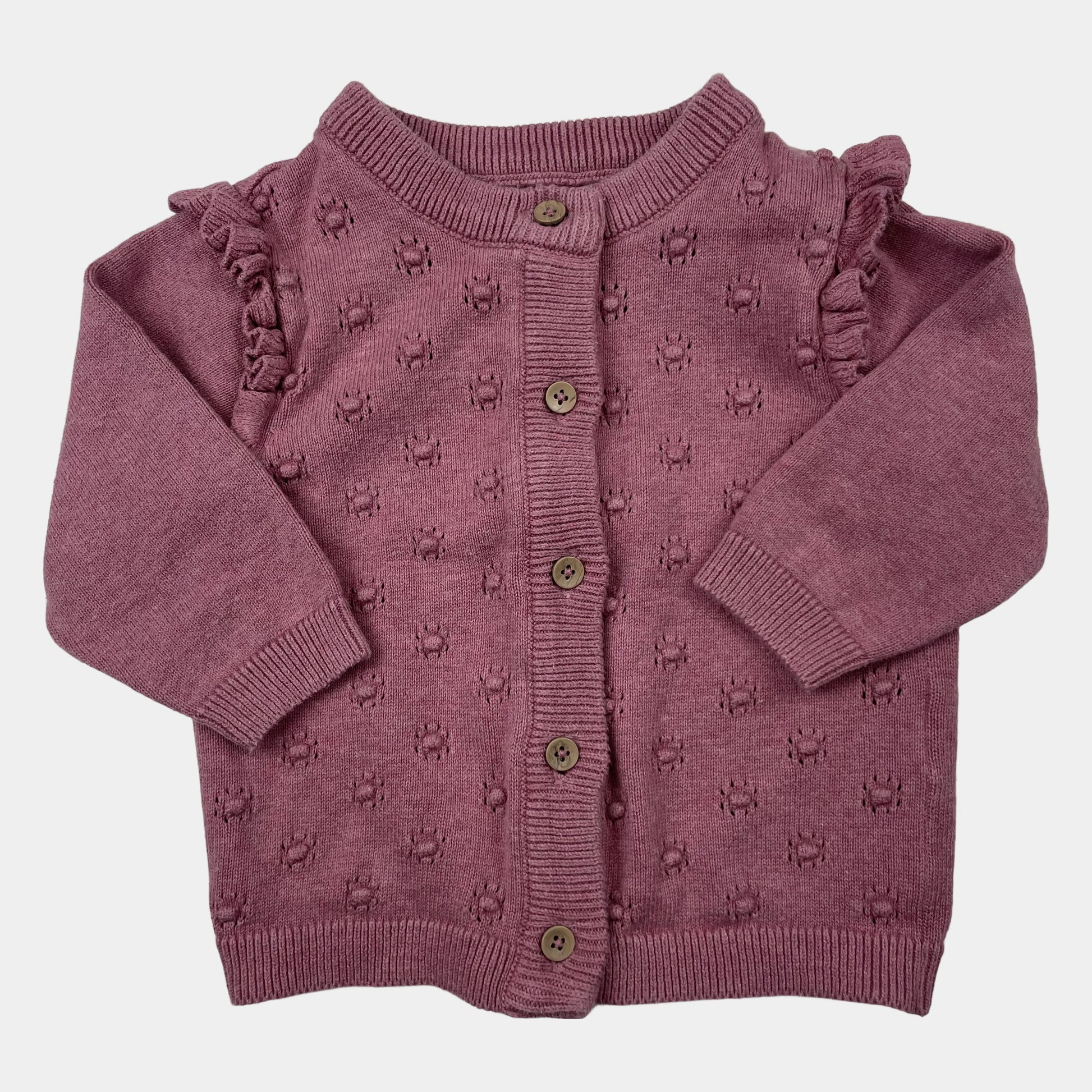 Lilafarbene Strickjacke für Babys mit Rüschen an den Schultern. – front