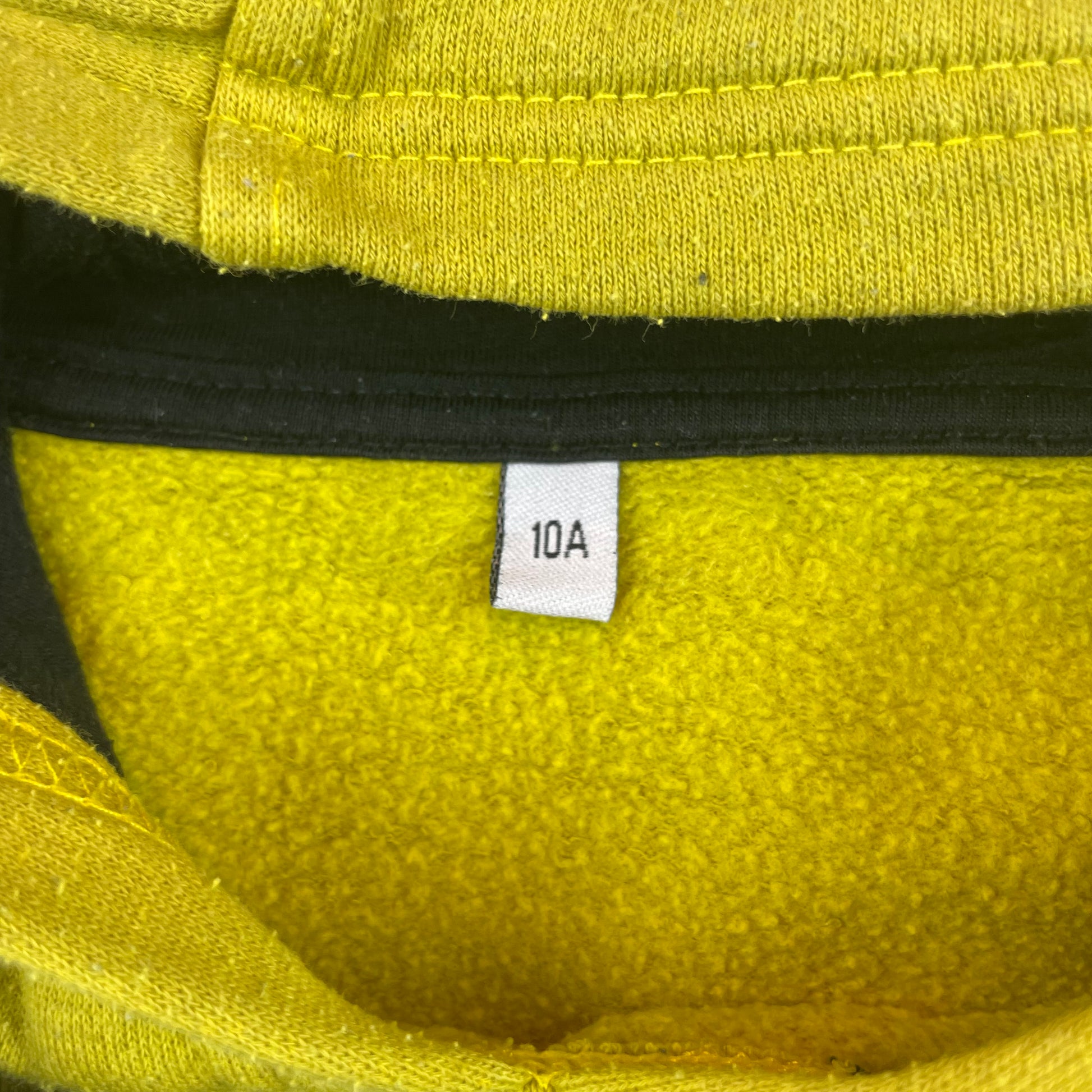 Grüner Hoodie mit Schriftzug "Explore the World" und Kapuze. – close‑up