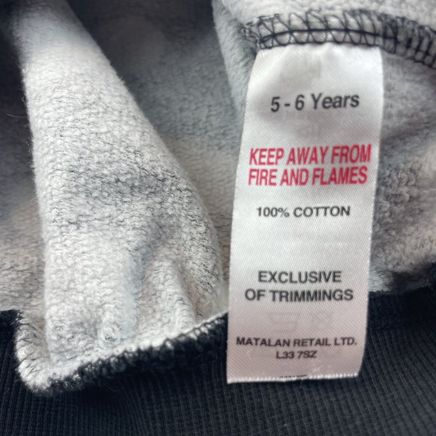 Schwarzer Baumwoll-Pullover mit weißen Punkten für Kinder. – label