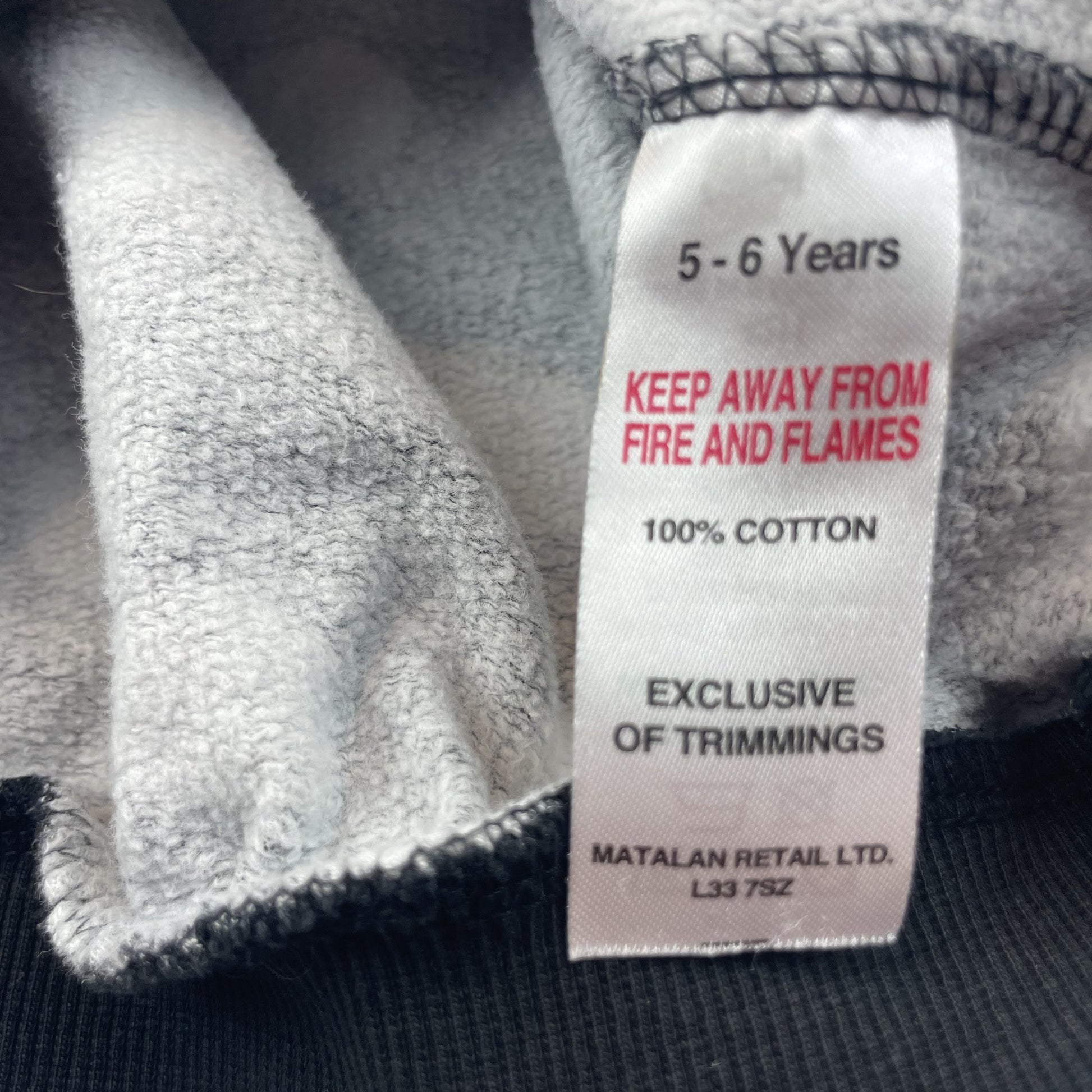 Schwarzer Baumwoll-Pullover mit weißen Punkten für Kinder. – label