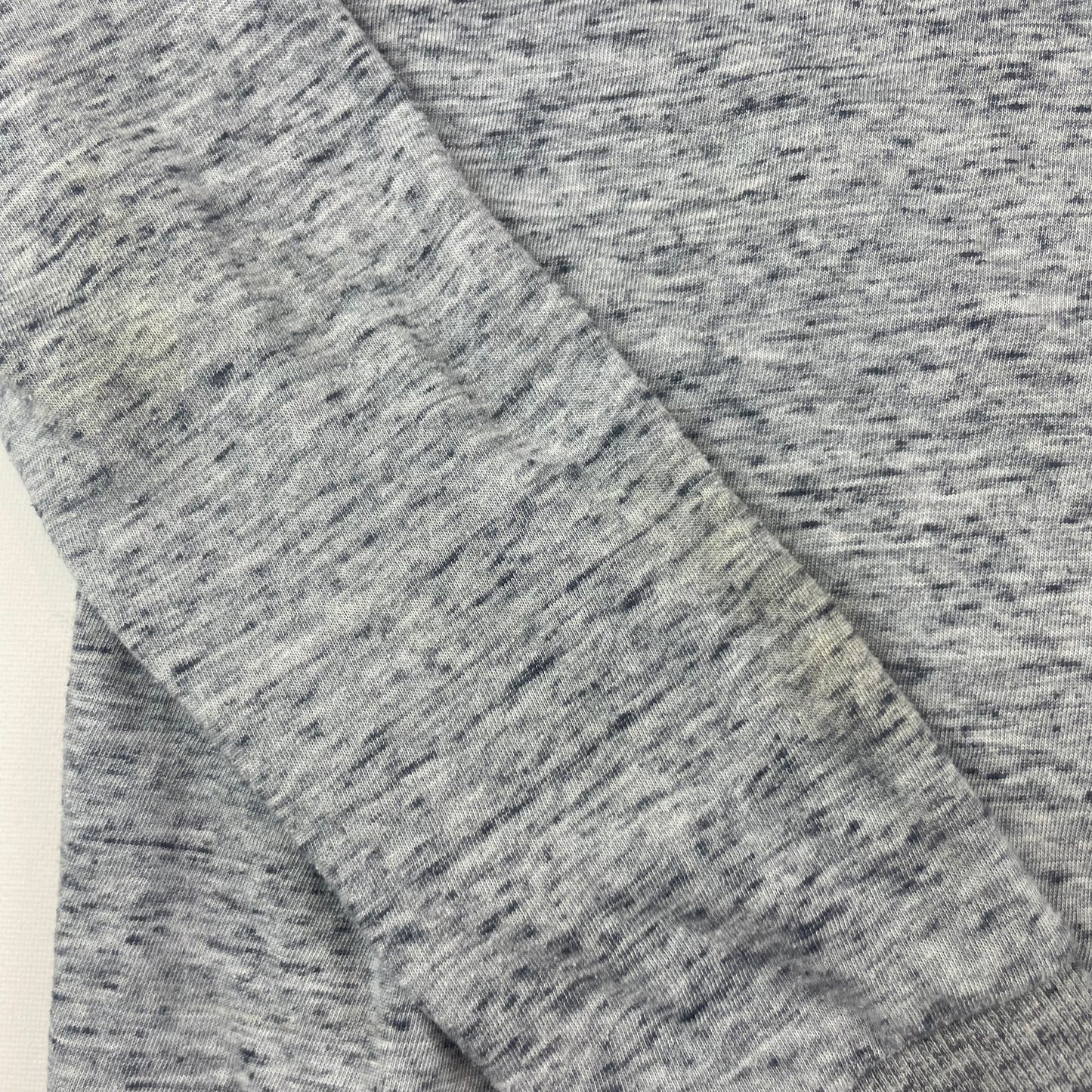 Grauer Pullover aus weichem Material mit Rundhalsausschnitt. – detail