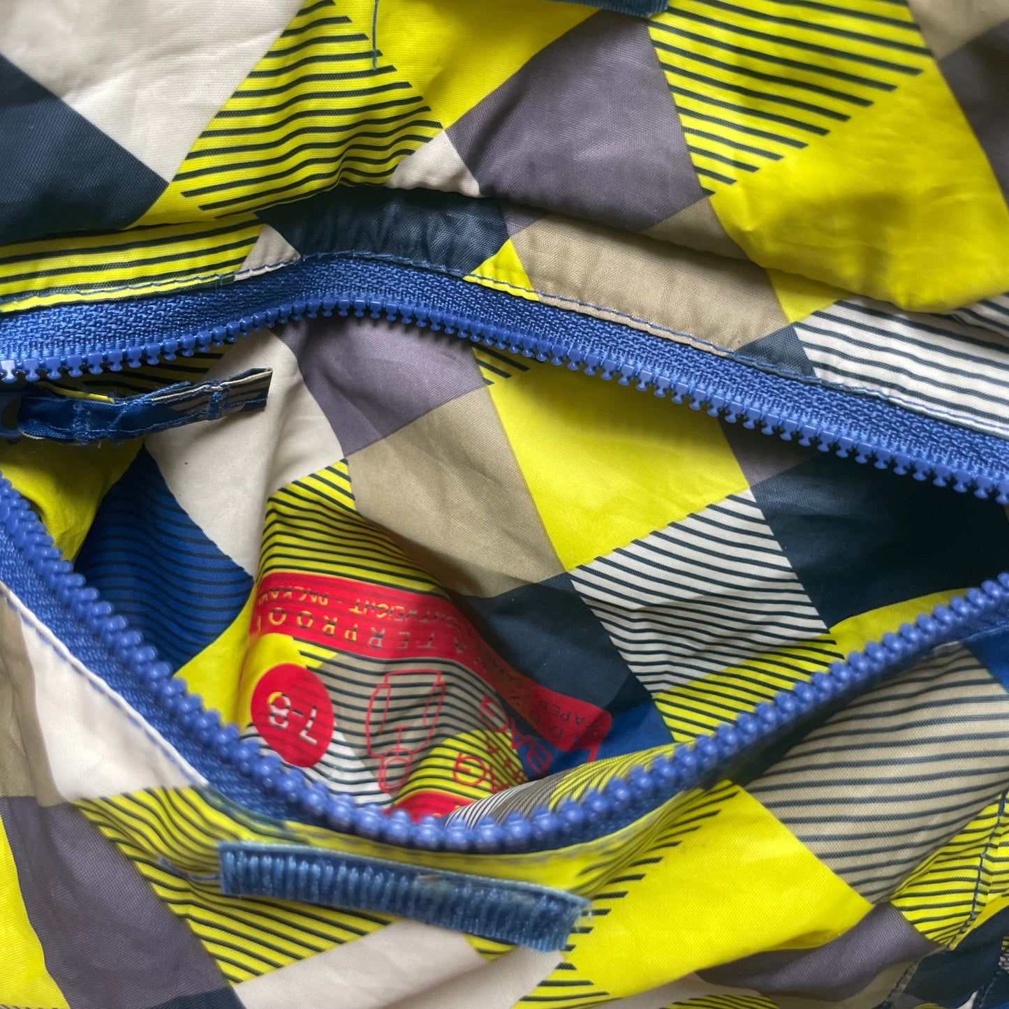 Mehrfarbige Regenjacke mit Kapuze und quadratischem Muster – pocket