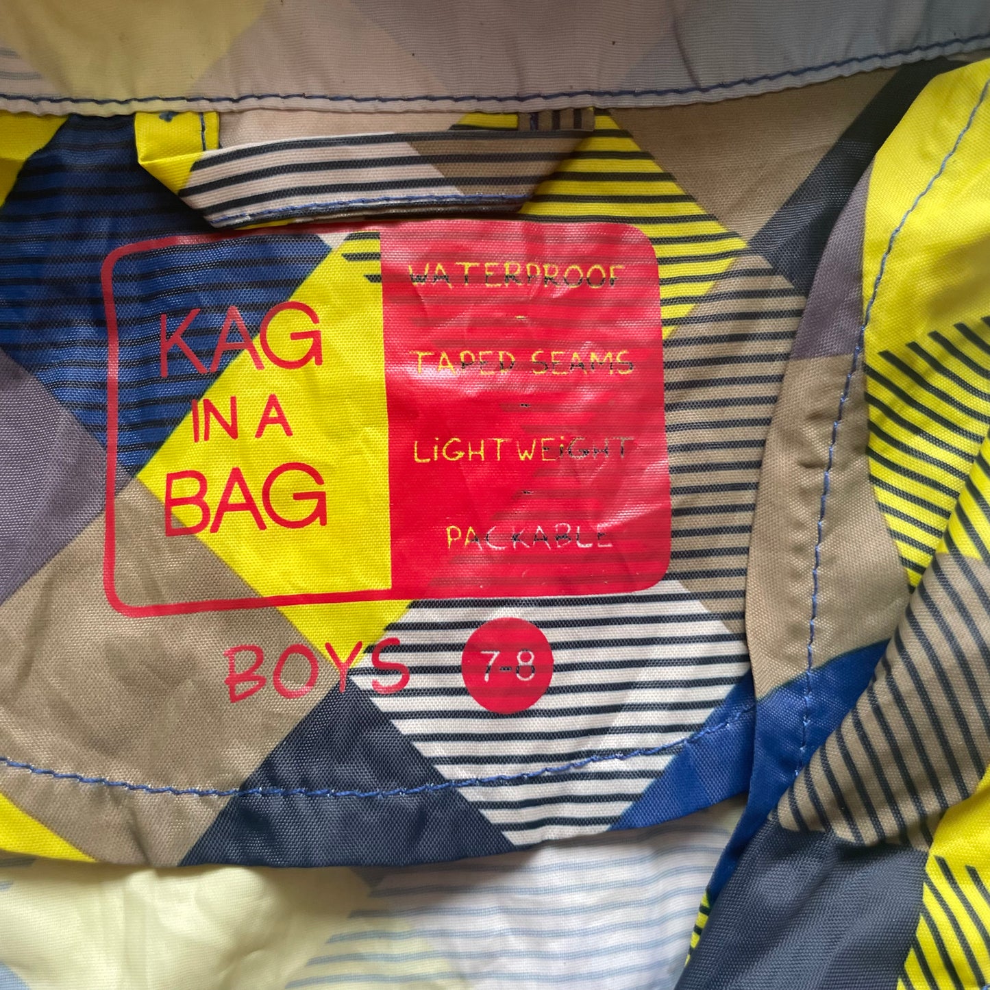 Mehrfarbige Regenjacke mit Kapuze und quadratischem Muster – label