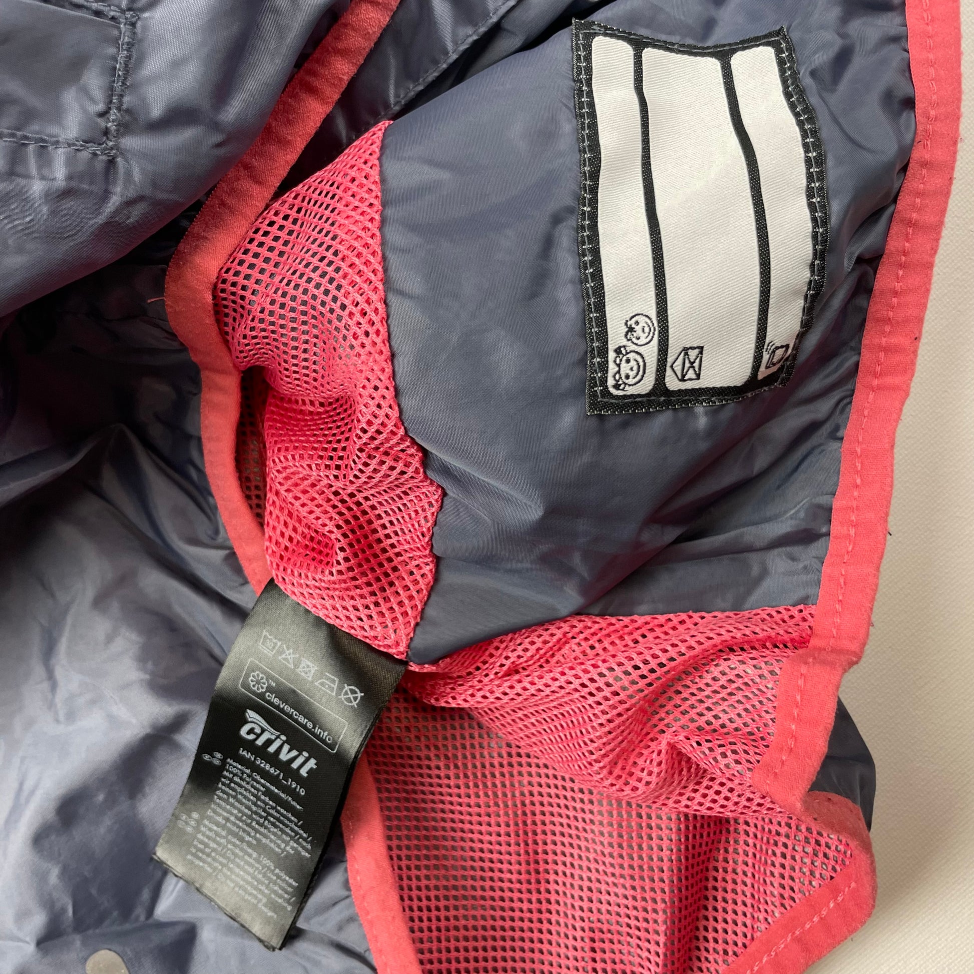 Graue Windjacke mit pinken Details und Kapuze von Crivit – label