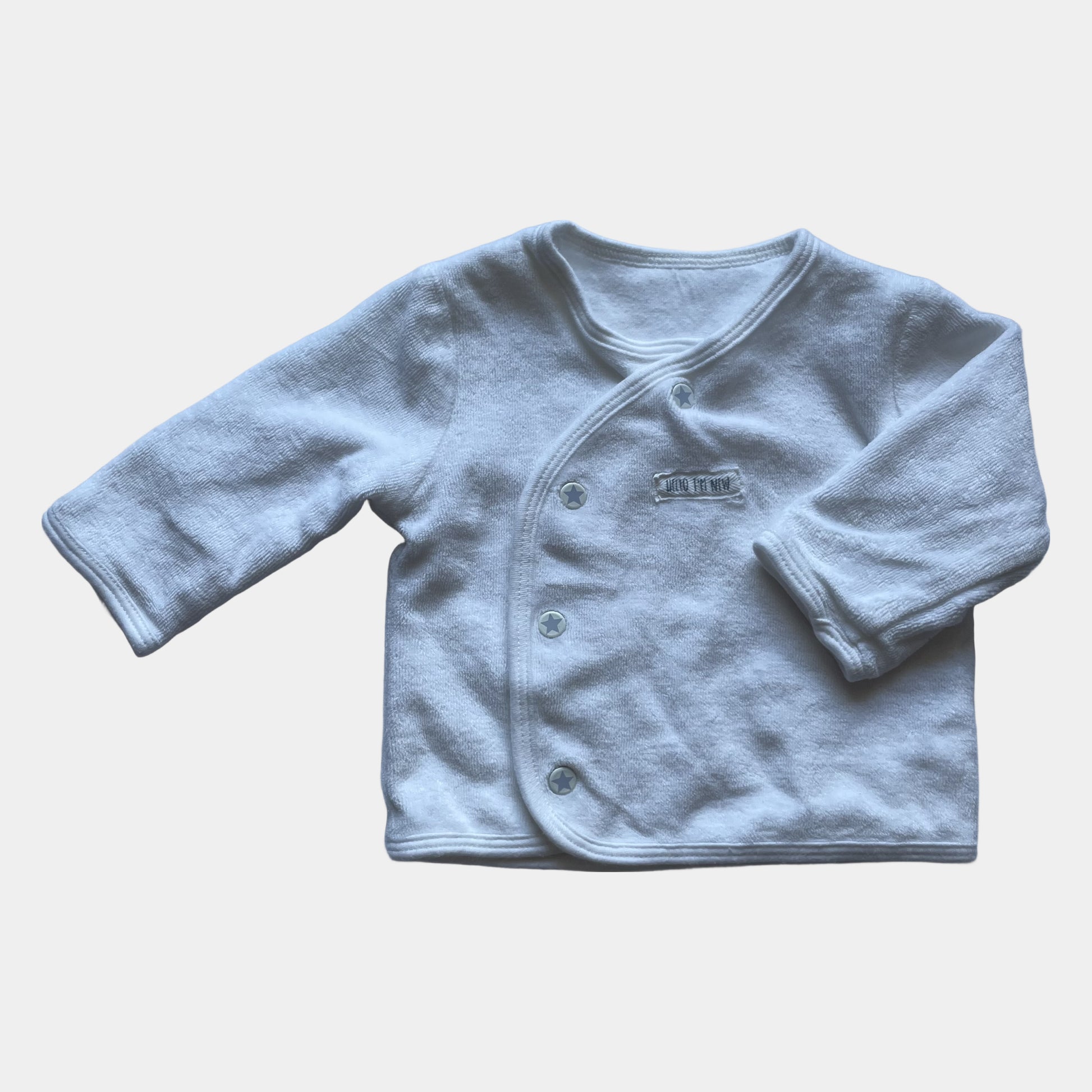 Weiße Strickjacke aus weichem Material mit Knöpfen und langen Ärmeln. – front