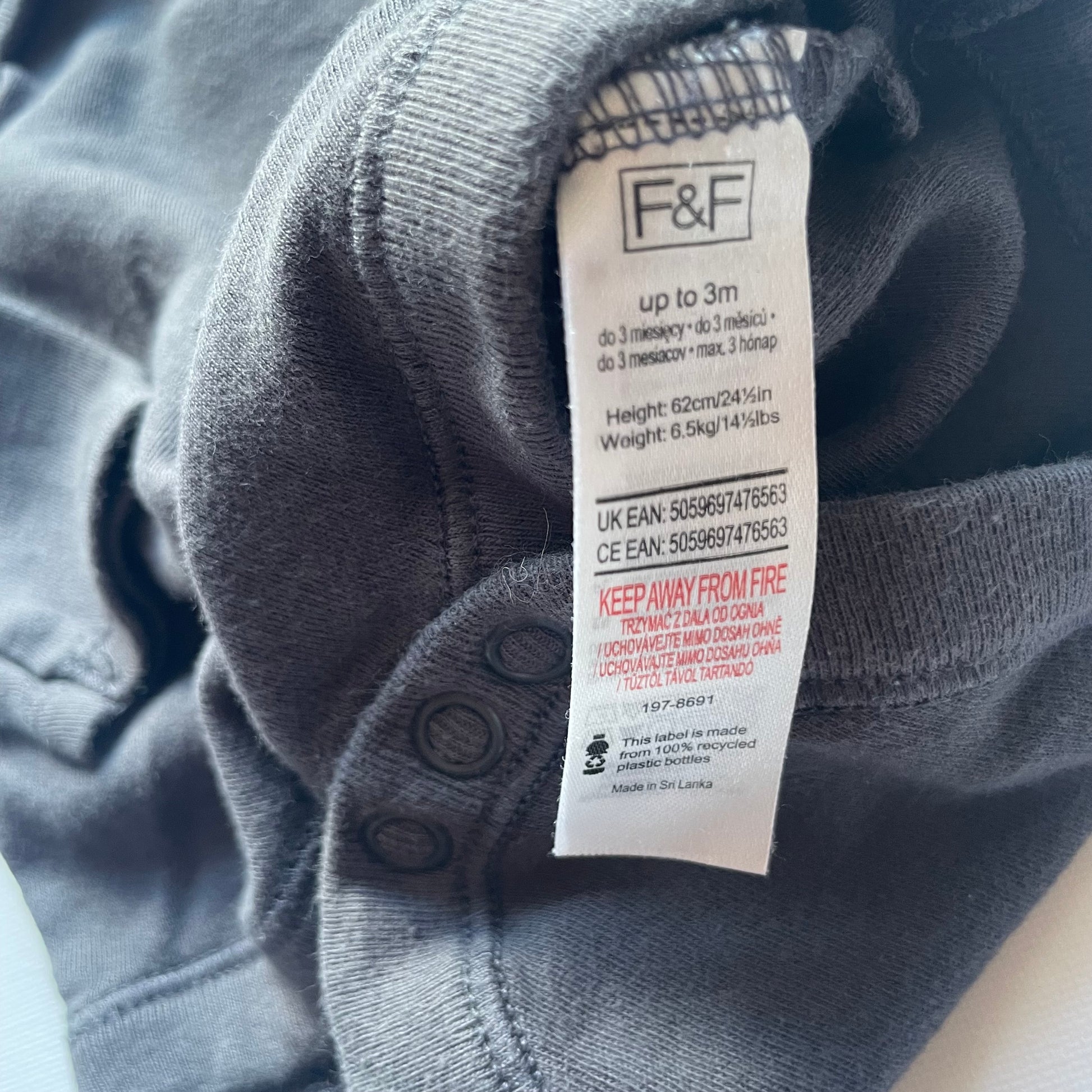 Grauer Langarm-Body aus Baumwolle mit Druckknöpfen im Schritt für Babys bis zu 3 Monate. – label