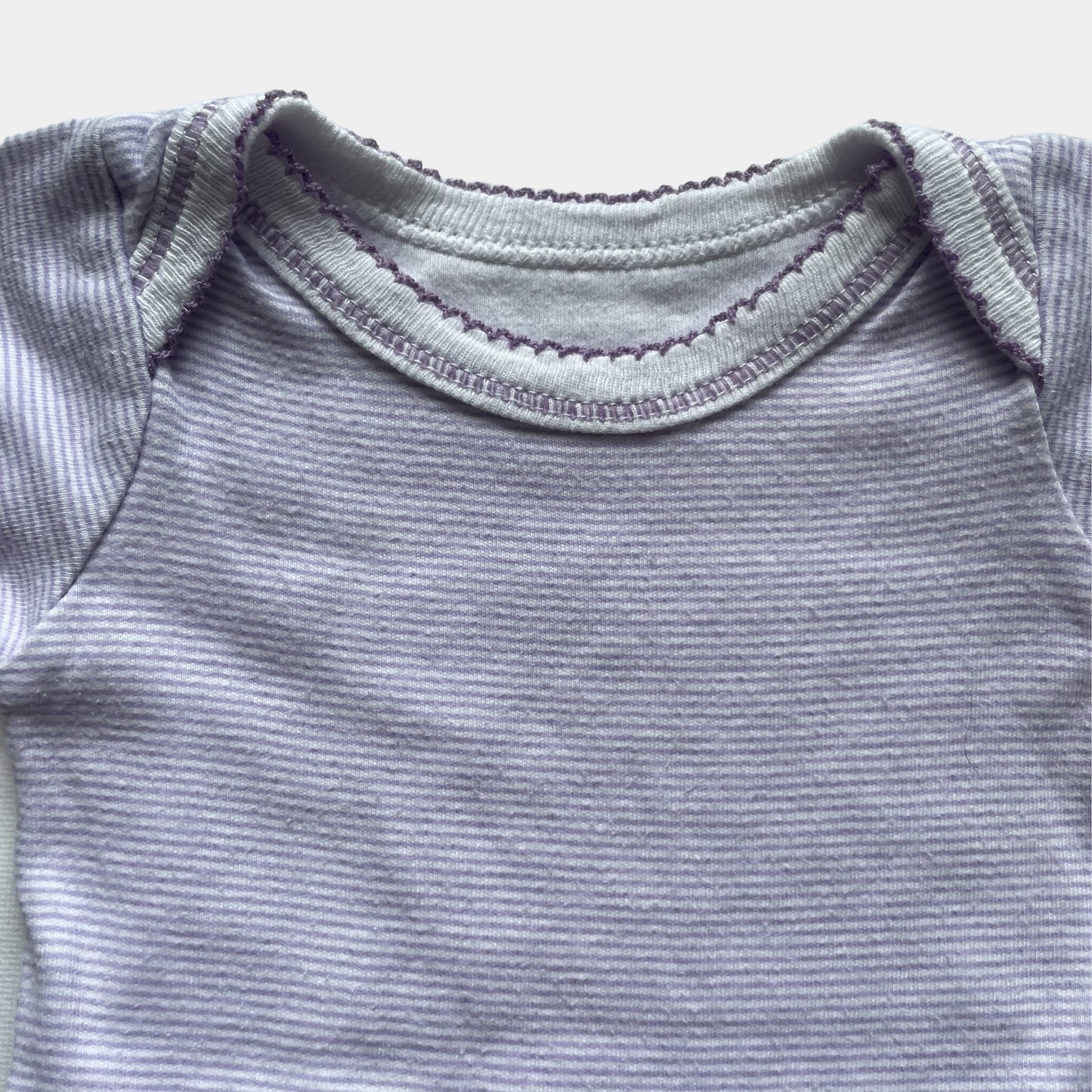 Lila gestreifter Baby-Body aus Baumwolle mit kurzen Ärmeln. – detail