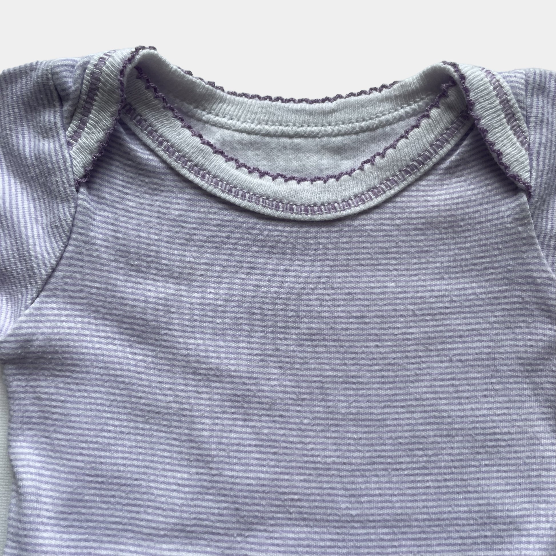 Lila gestreifter Baby-Body aus Baumwolle mit kurzen Ärmeln. – detail