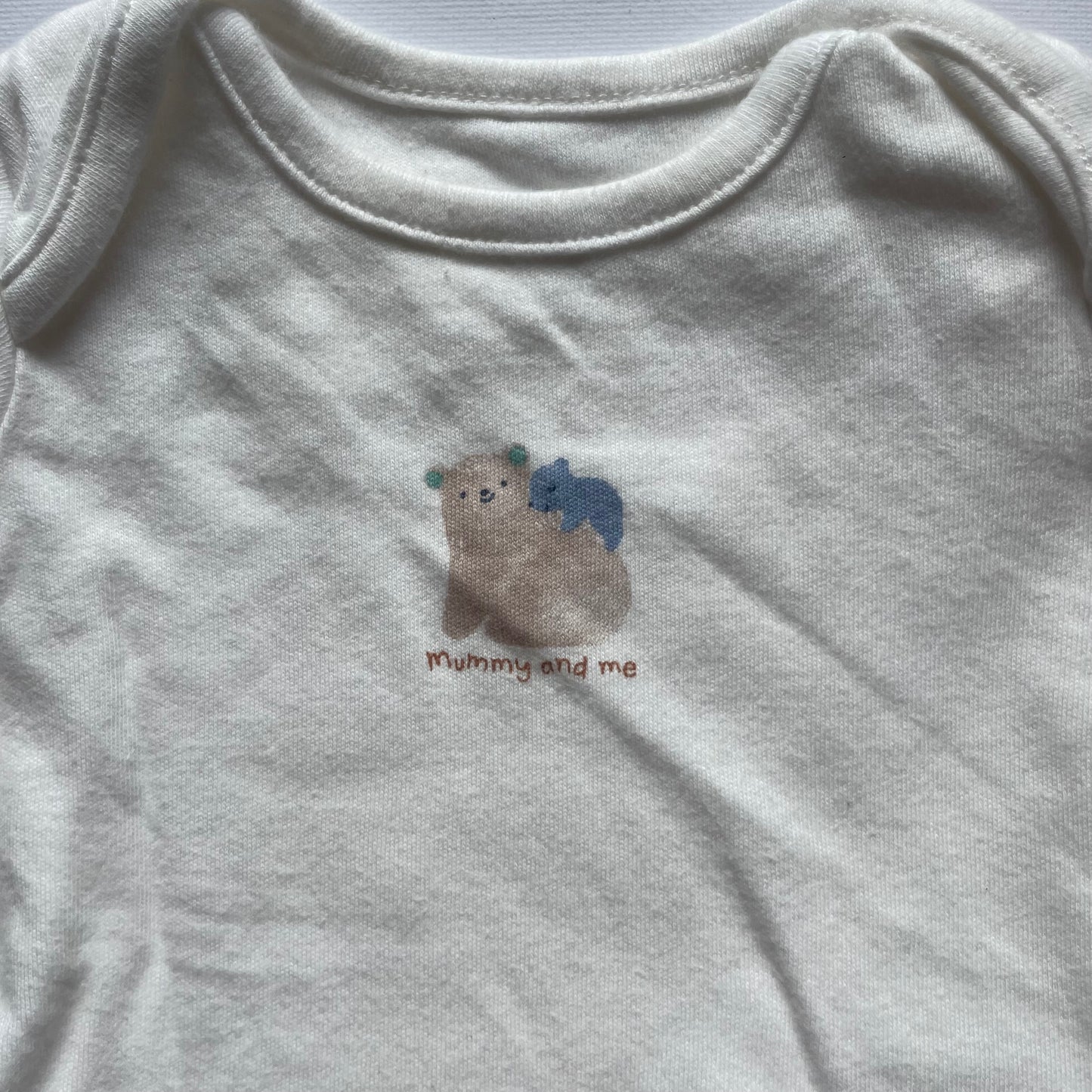 Weißer Baumwoll-Body mit Bärenmotiv für Neugeborene. – detail