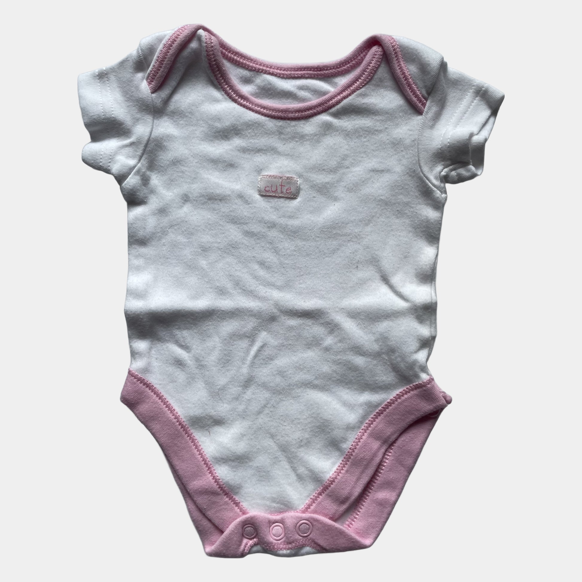 Weißer Babybody von George mit rosa Paspeln. – front