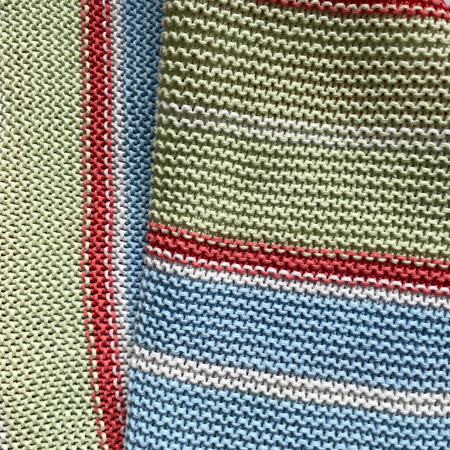 Bunte Babydecke mit Streifen in Grün, Blau und Rot. – detail