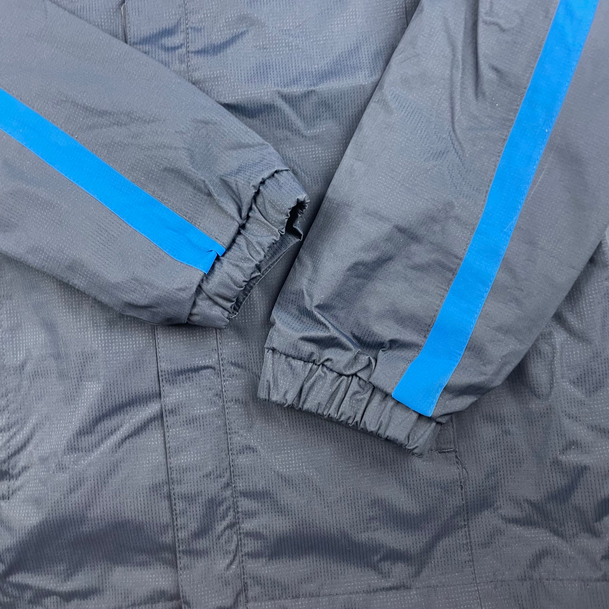 Dunkelblaue Polyester-Regenjacke mit Kapuze und blauen Streifen. – sleeve