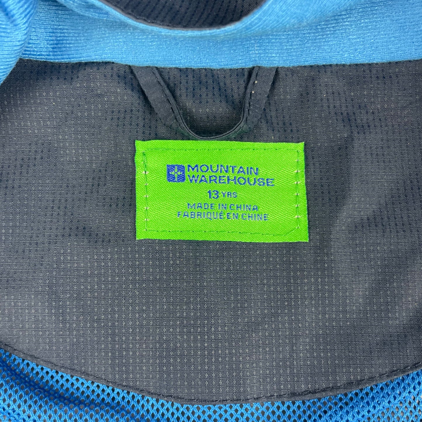Dunkelblaue Polyester-Regenjacke mit Kapuze und blauen Streifen. – label